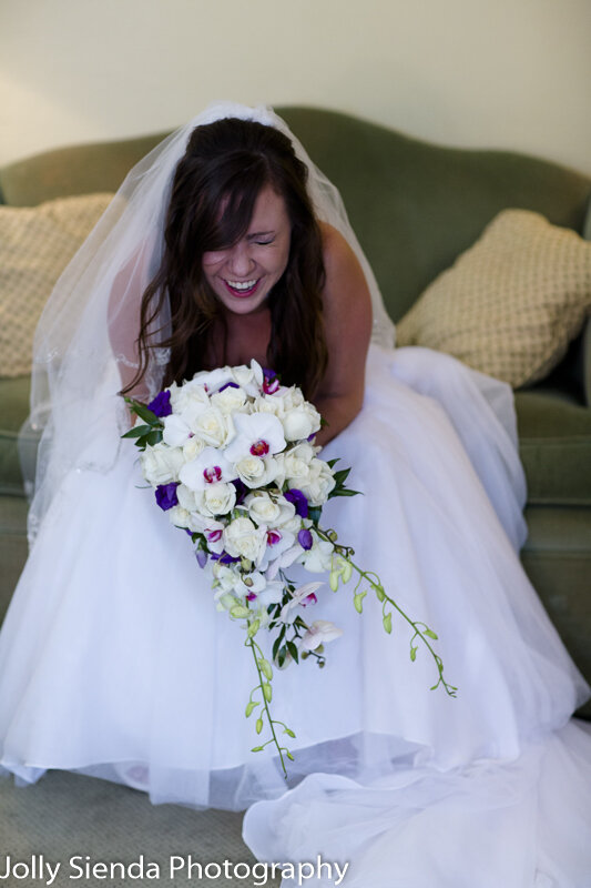 Wedding photography for the bride laughing with her orchid weddi