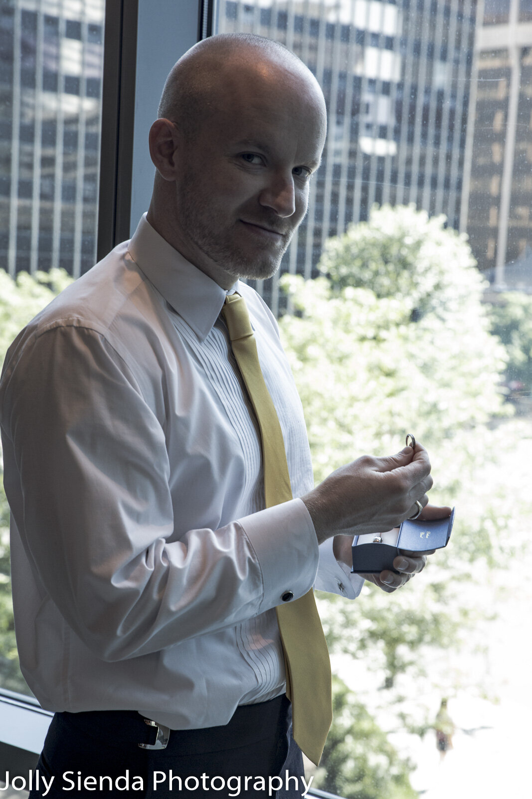 Portrait of a groom looking at the wedding rings