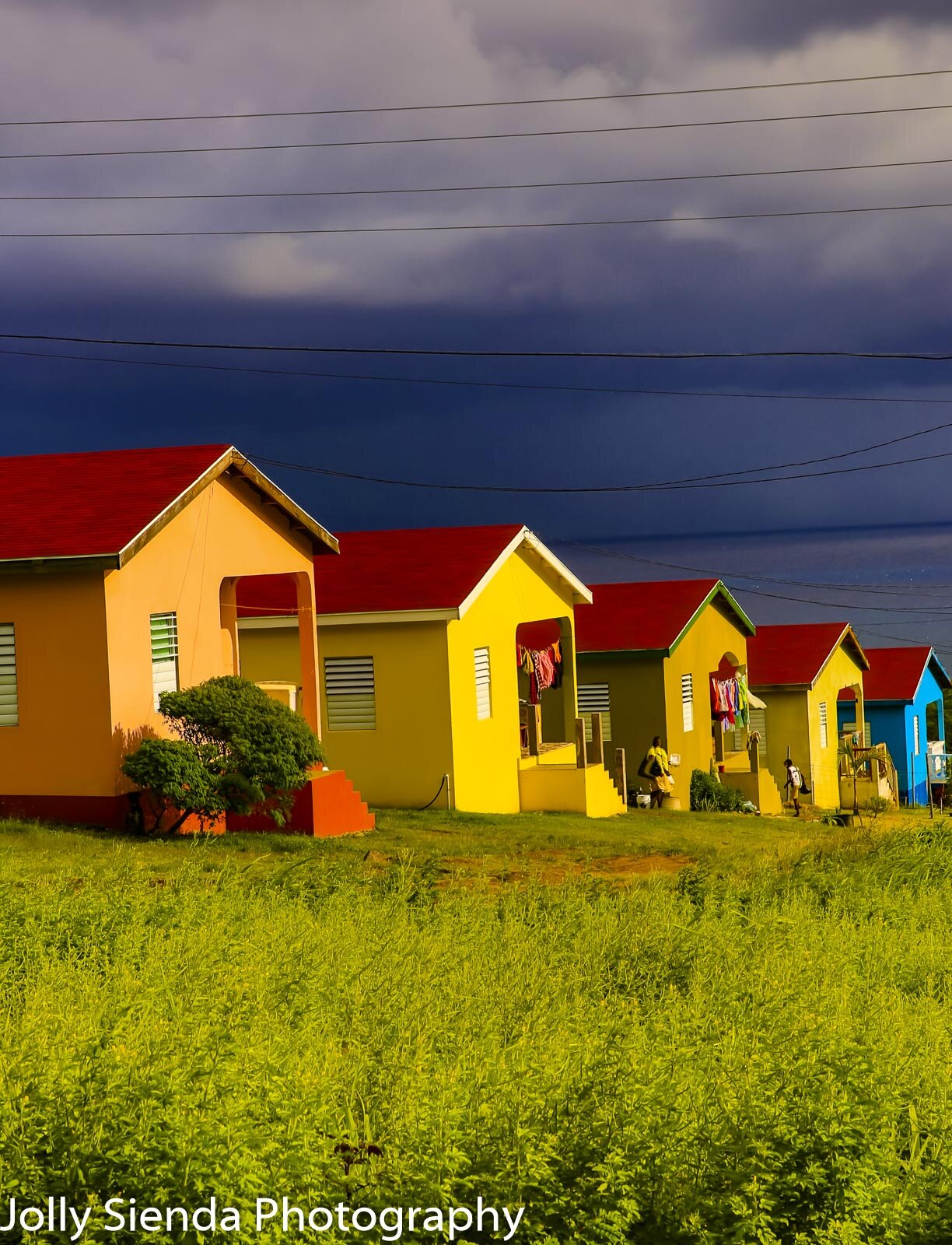 Colorful, Caribbean row houses, hanging laundry, meadow, people