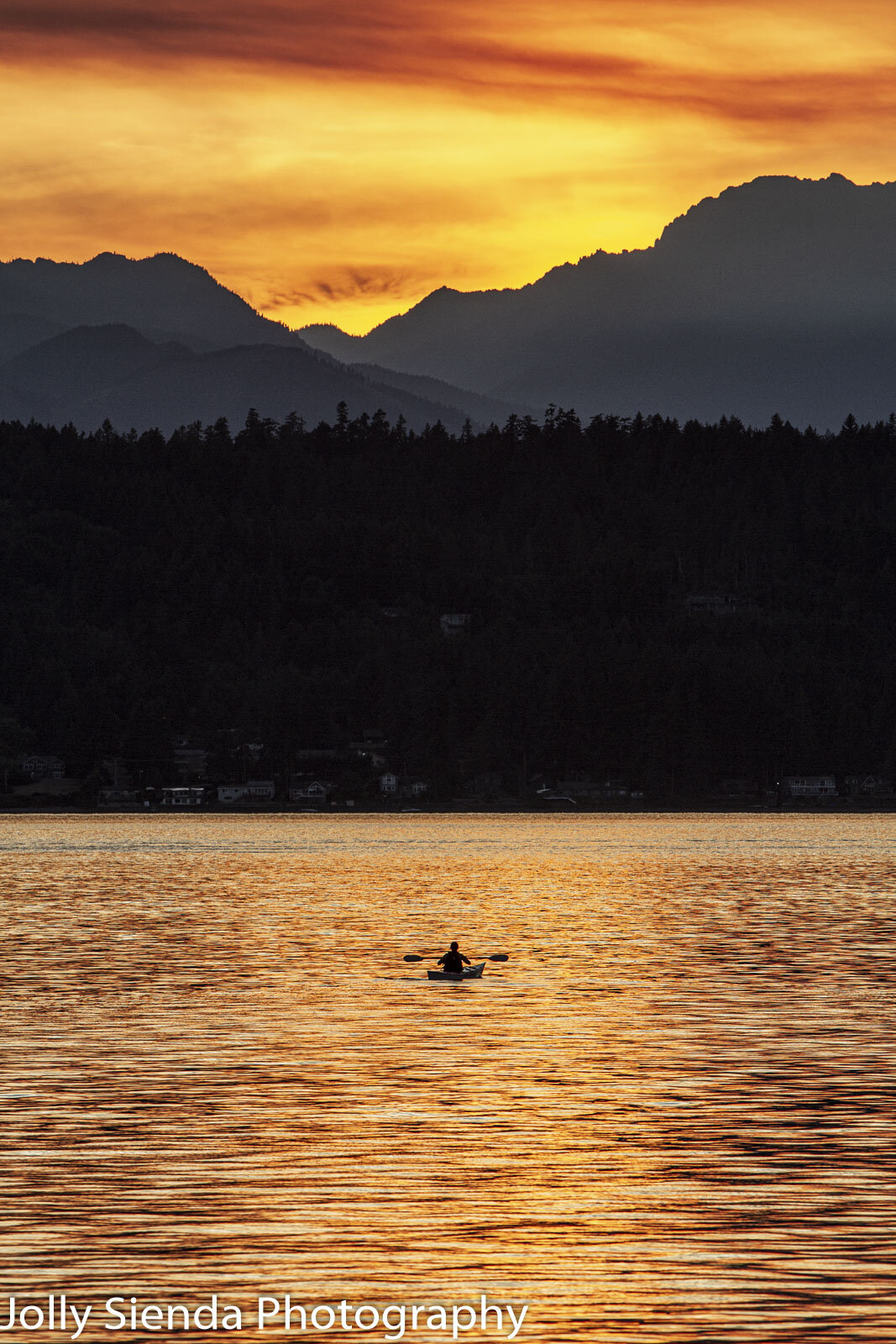Kayaker rests oars on Puget Sound 