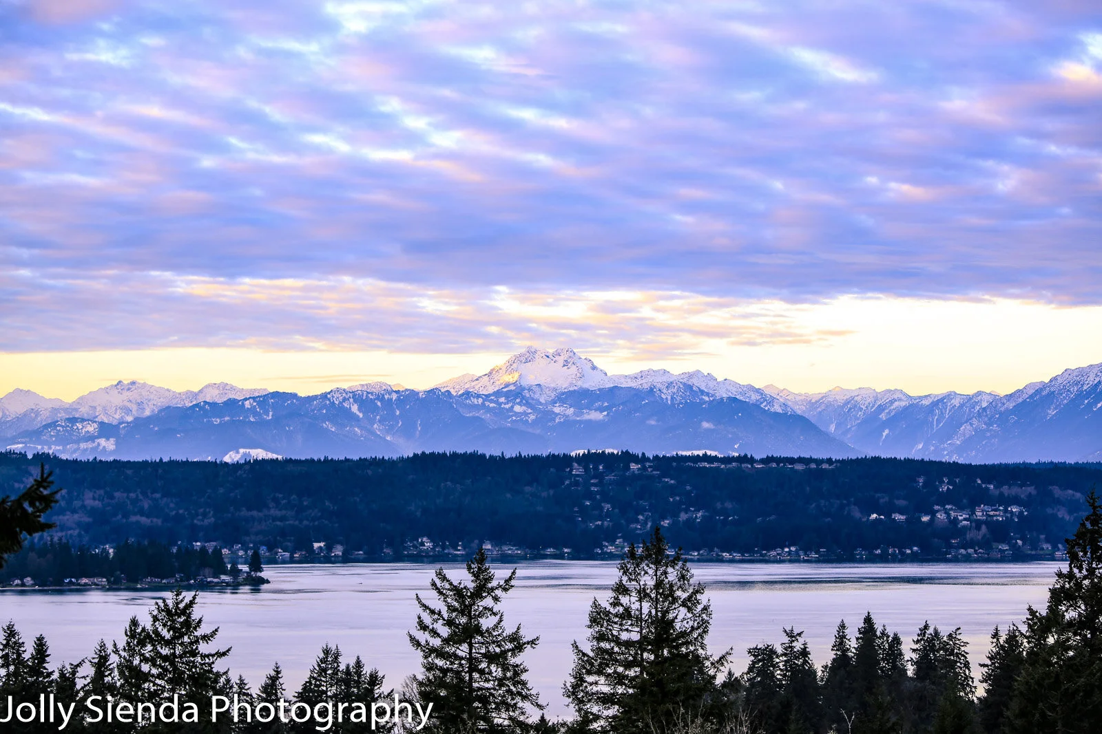 Pastel cumulus clouds rise over snow covered Olympic Mountains a (Copy)