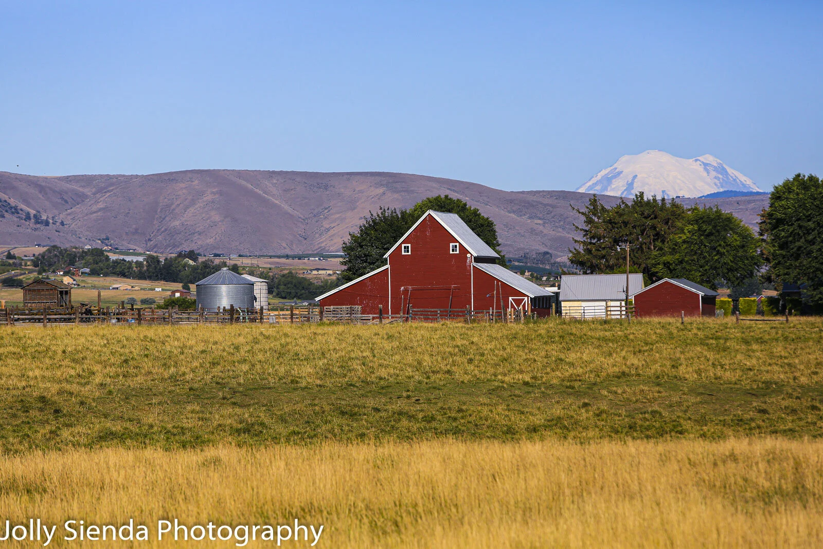 The red barn, silos, and Mount Rainier peaking over Manastash Ra