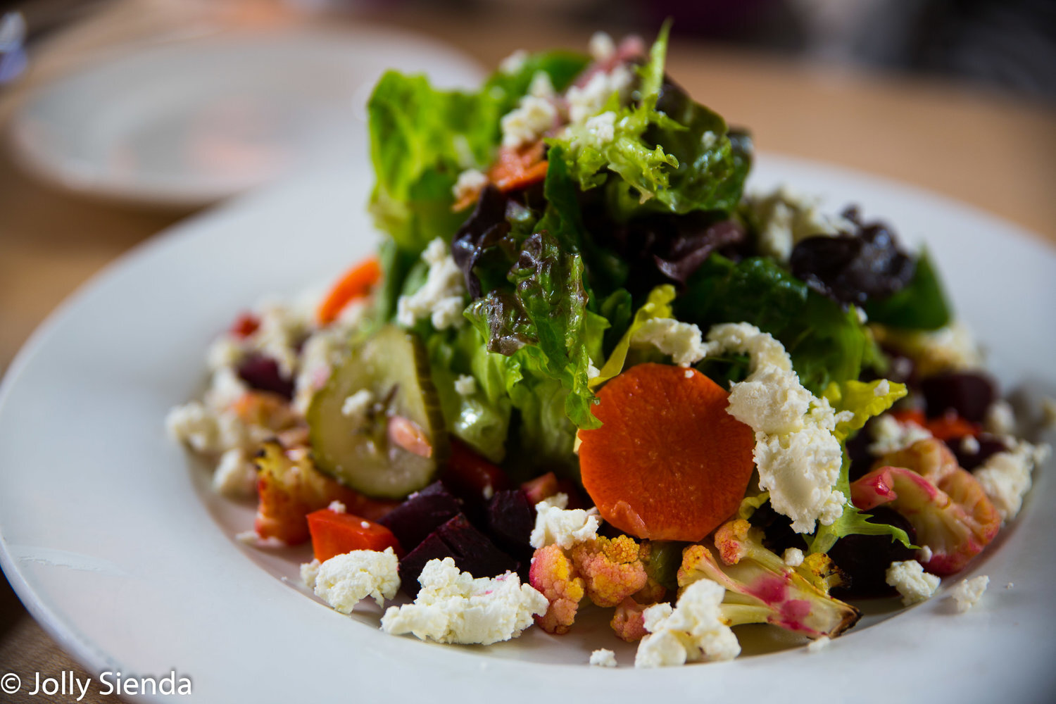 Fresh green leaf salad with beets, carrots, cucumber, and marina