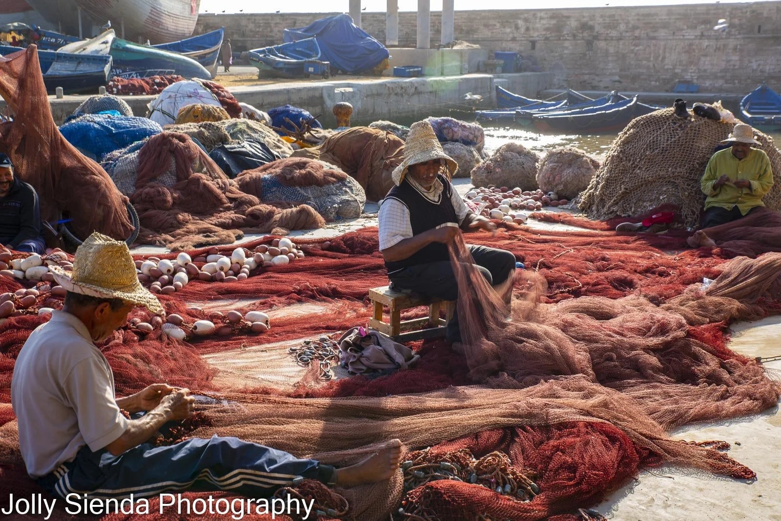 Fishermen repair fish nets