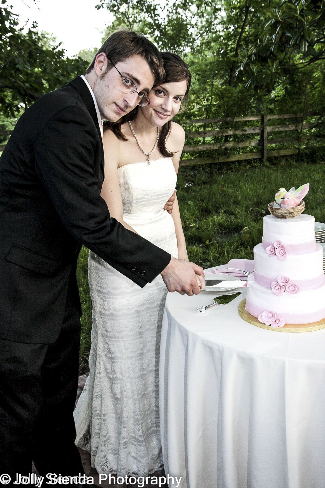 Cutting the wedding cake by Jolly Sienda Photography