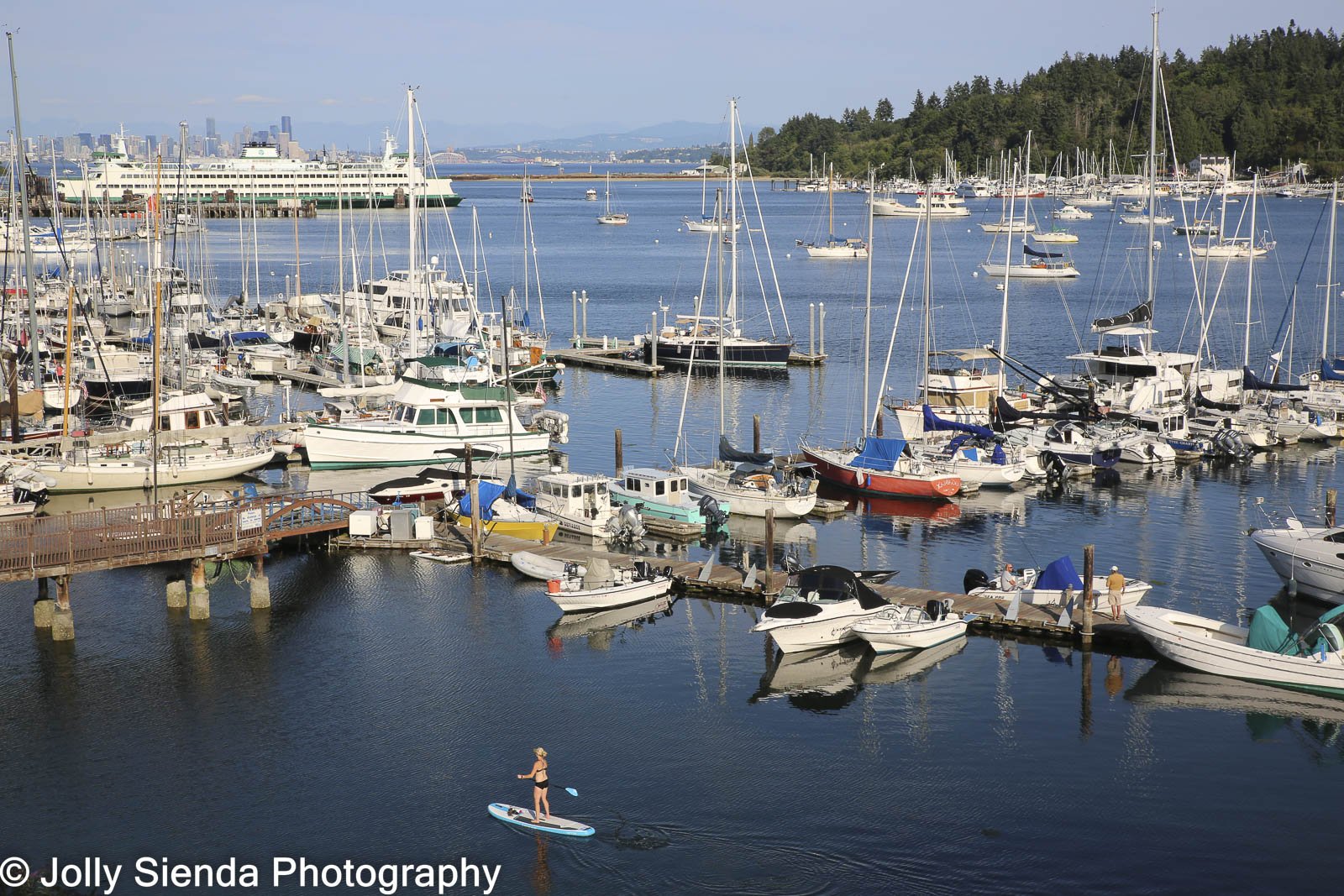 Paddle boarding in Bainbridge Island Marina with boats and ferry