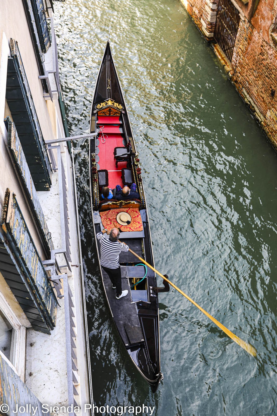 aerial view of a gondolier and gondola sailing the canal