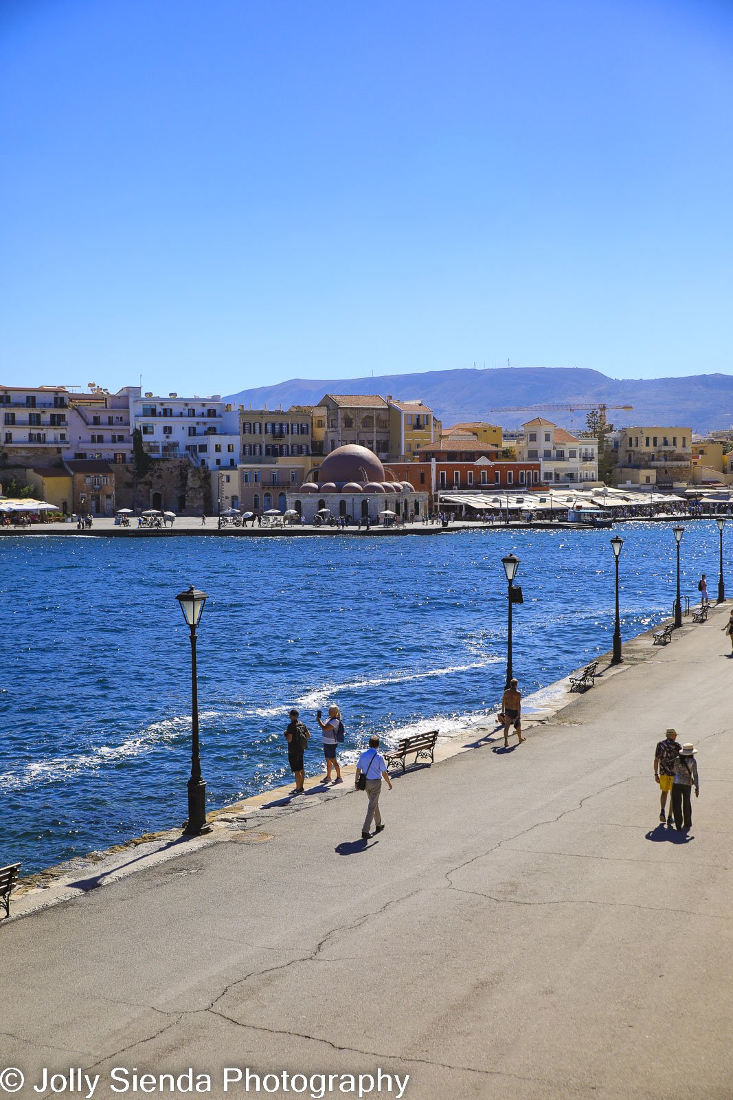 People walking along Greek Venetian waterfront  and old town