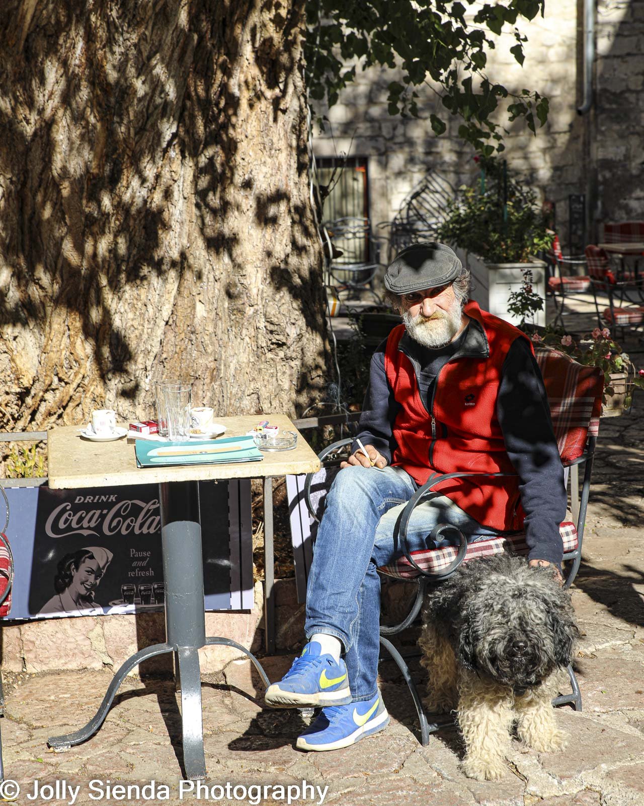 Man and his dog at an outdoor cafe in a park