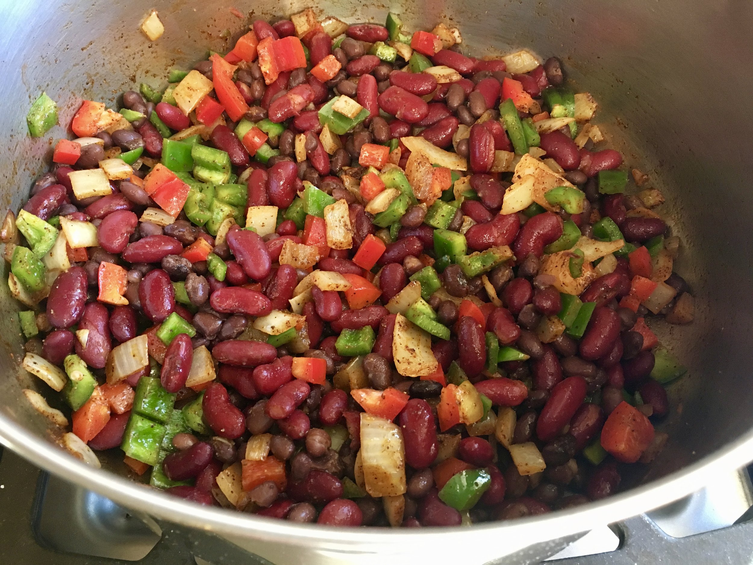 Here’s the start of a Mexican-themed soup with loads of peppers, black and kidney beans, onions, chili powder and cumin. Frozen crushed tomatoes and chicken broth come next. The rich flavor of the garden peppers made this batch the best ever.