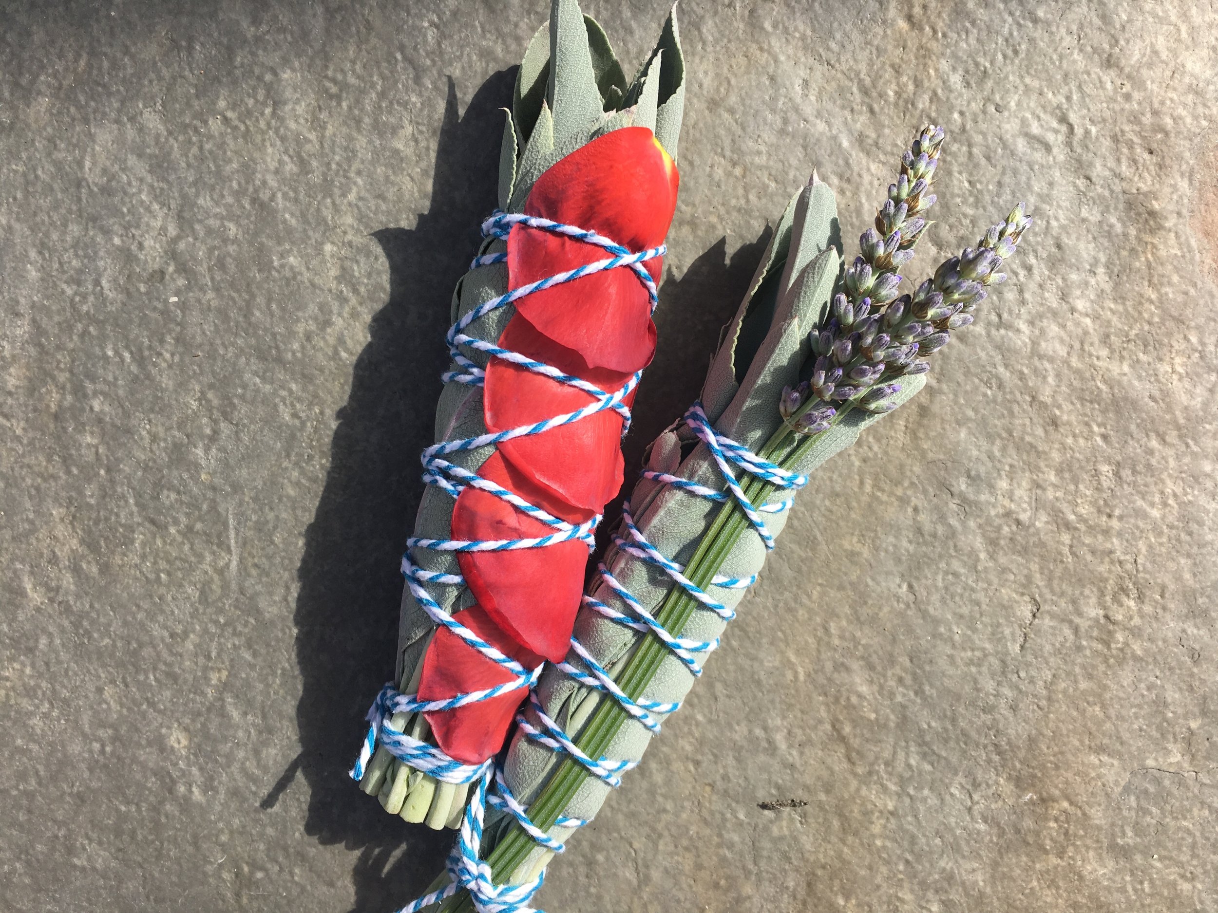 White sage smudge sticks with rose petals and lavender.
