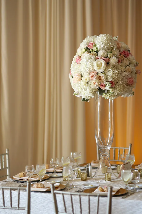Pink, white, and gold wedding reception in Cincinnati at The Center with florals by Yellow Canary Floral and Event Design. Gold chargers, gold votives, and silver chiavari chairs transformed the reception space.