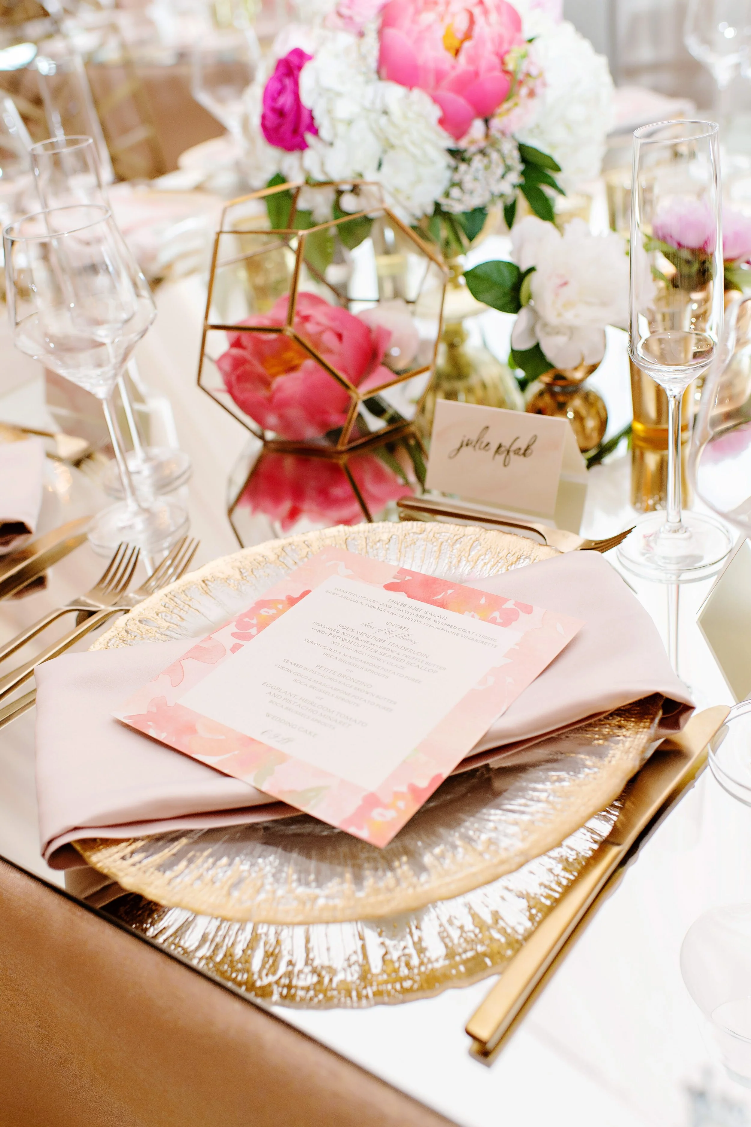 Table setting for tented reception with bright florals