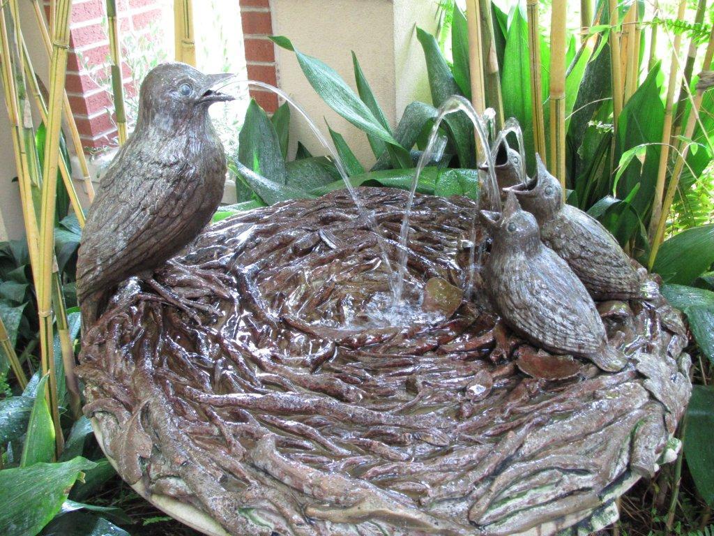 Mom and baby birds on nest fountain