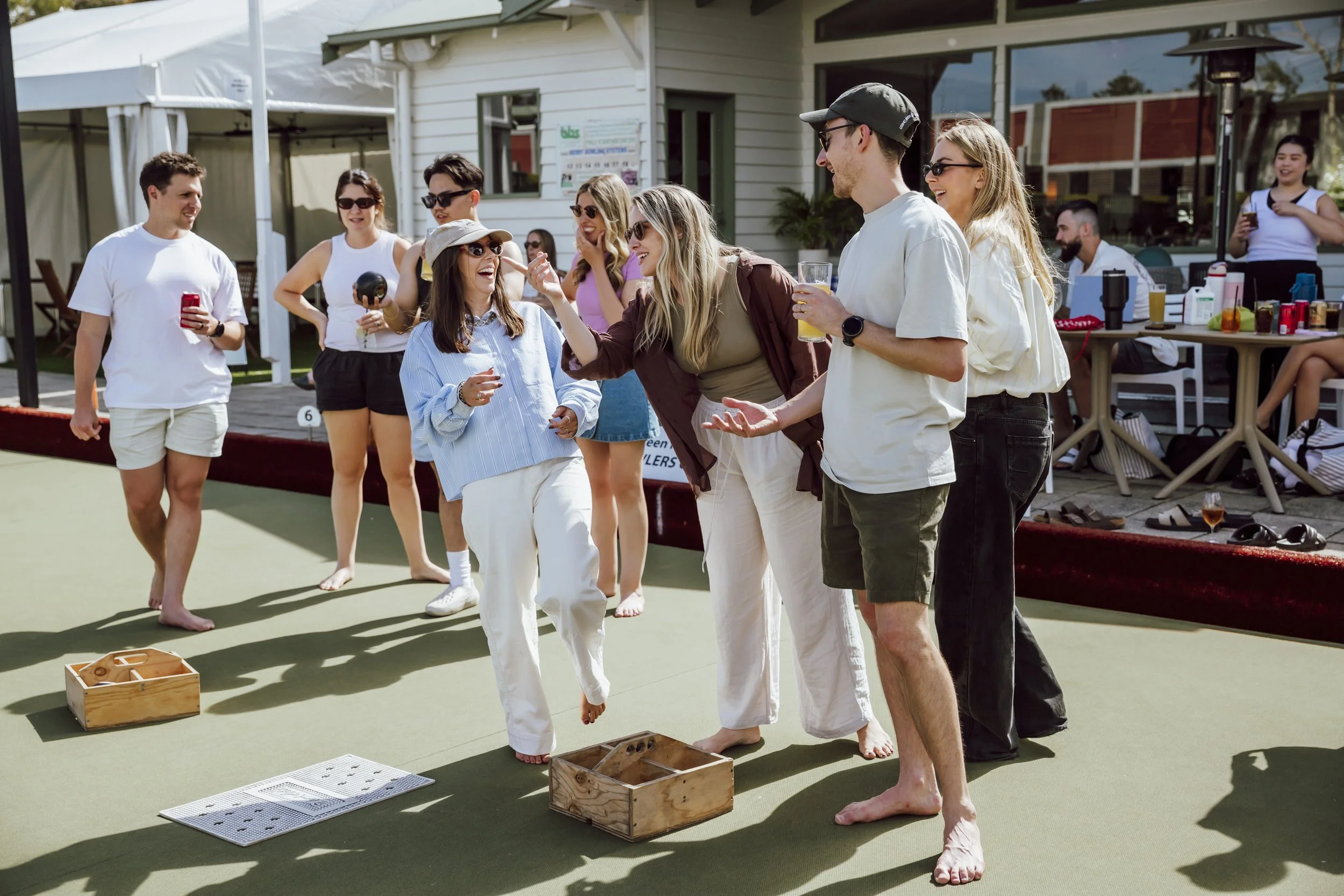 Team playing barefoot lawn bowls during a company team building day in Lorne