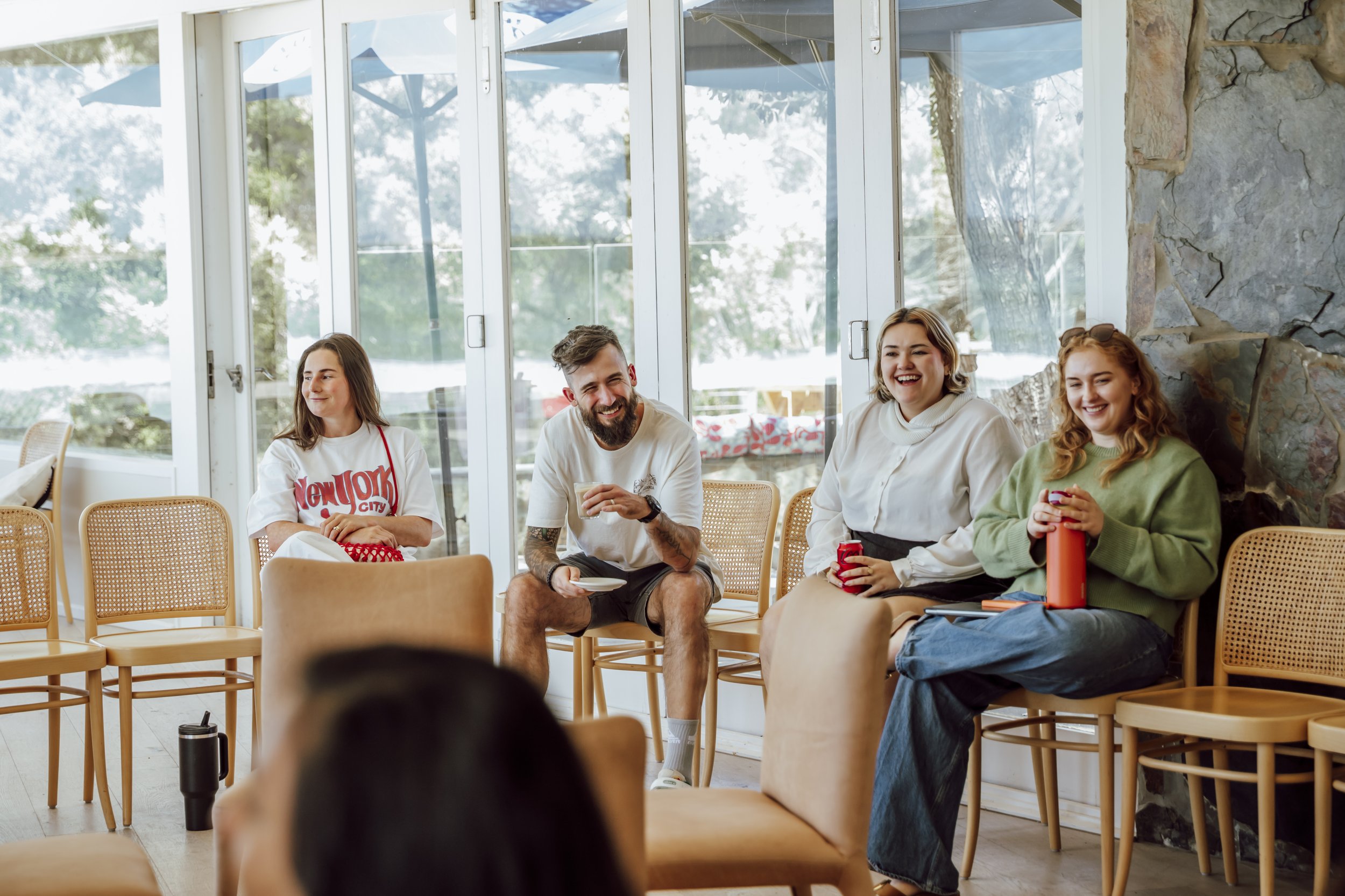 Team members relaxing and laughing between sessions at an offsite in Lorne
