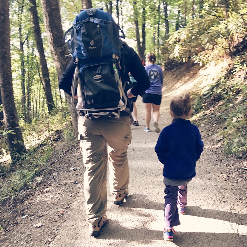 Nathan carrying Charlotte on his back and hiking with Mattie Grace to a waterfall we knew was on the end of our hike.