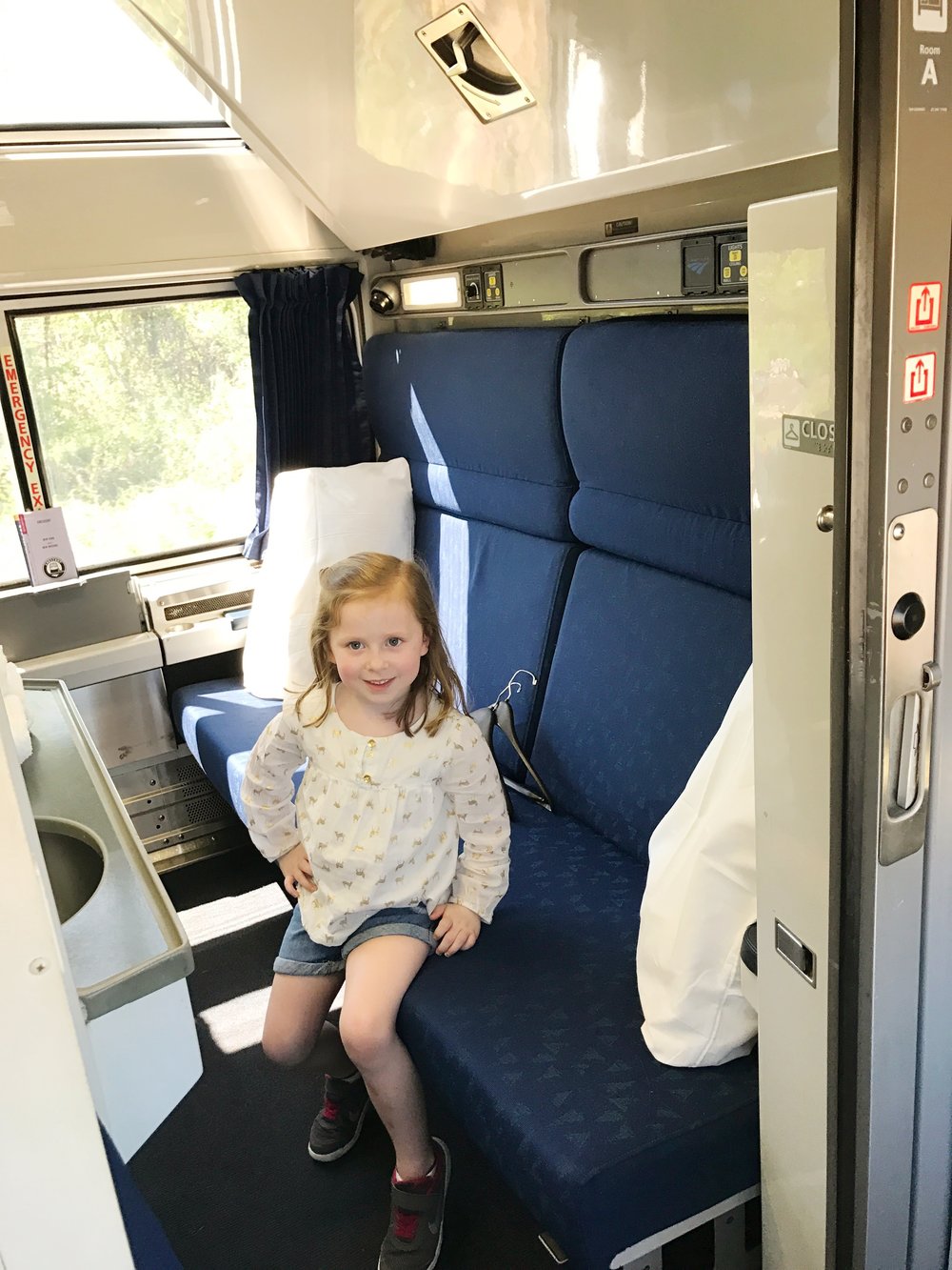Mattie Grace modeling a room on the Amtrak train - everything folds out to make two bunk beds!