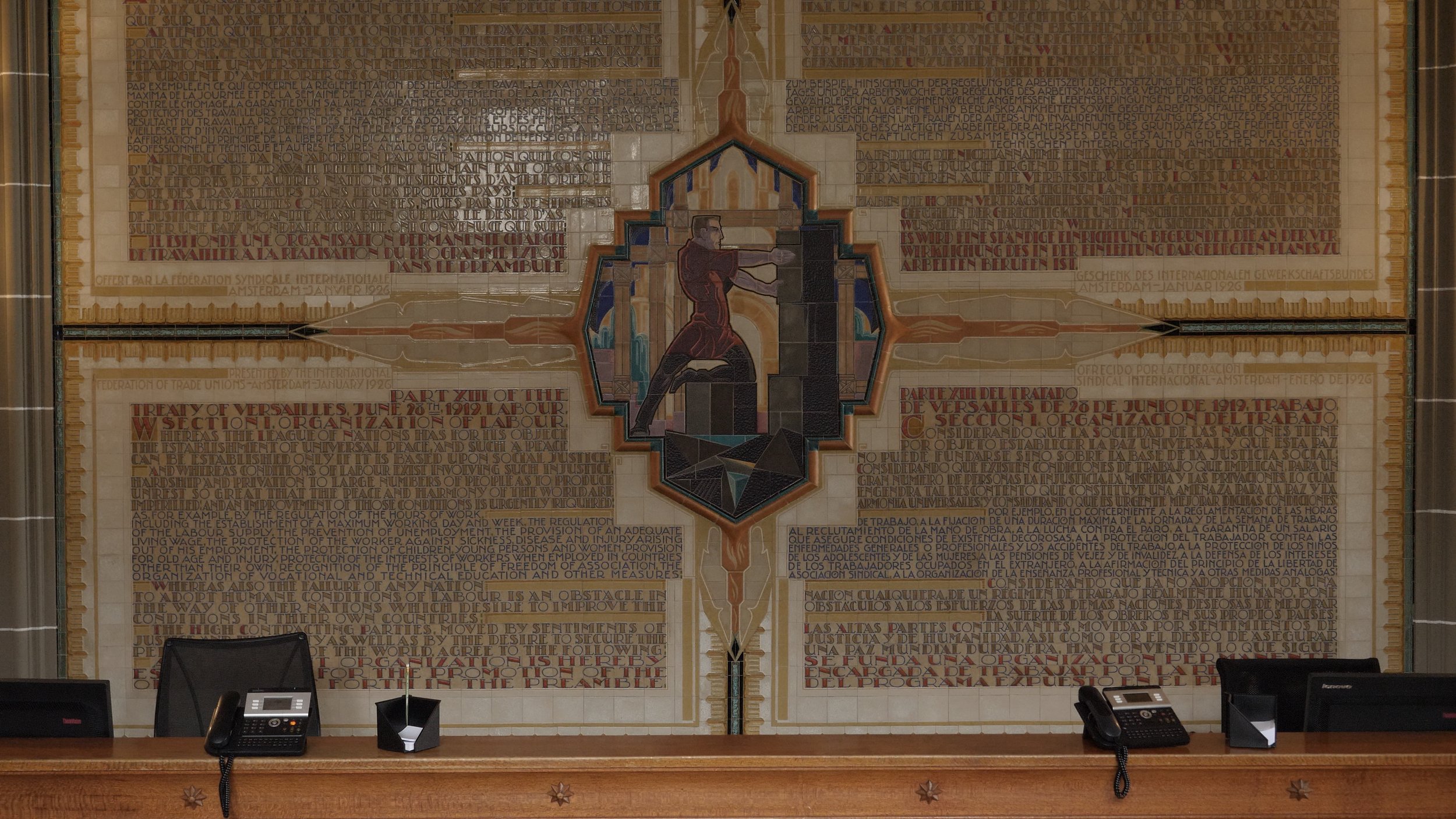 The Walls of the WTO | 10 minutes | 2018 | Ryan S Jeffery & Quinn Slobodian A ten minute short video that explores the origins of the idea of a global economy through the artwork on the walls of a unique building, the Centre William Rappard in Geneva, once the home of the International Labour Organization and now the headquarters of the World Trade Organization. Tracing the appearance, erasure and reappearance of the toiling human body on the artwork of the building’s walls, they tell the story of a global capitalist project as a transnational system of governance where the flow of capital across borders is protected as a human right, while the movement of people is met with proliferating forms of restriction and regulation.