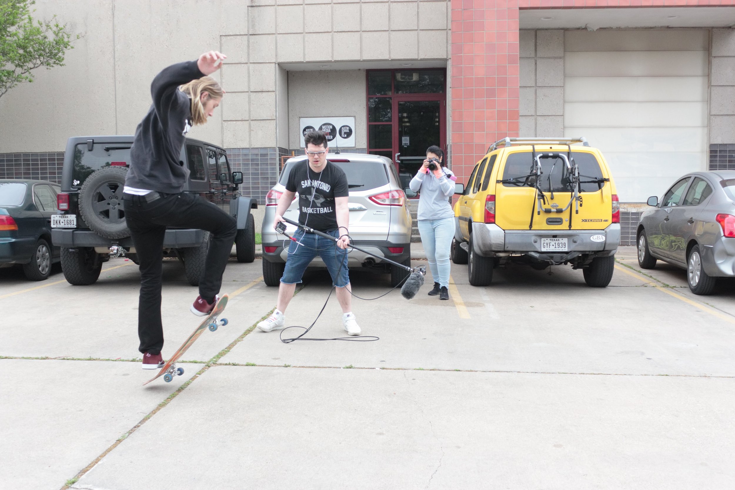 Joel operating a boom microphone outside of Motion Media Arts Center