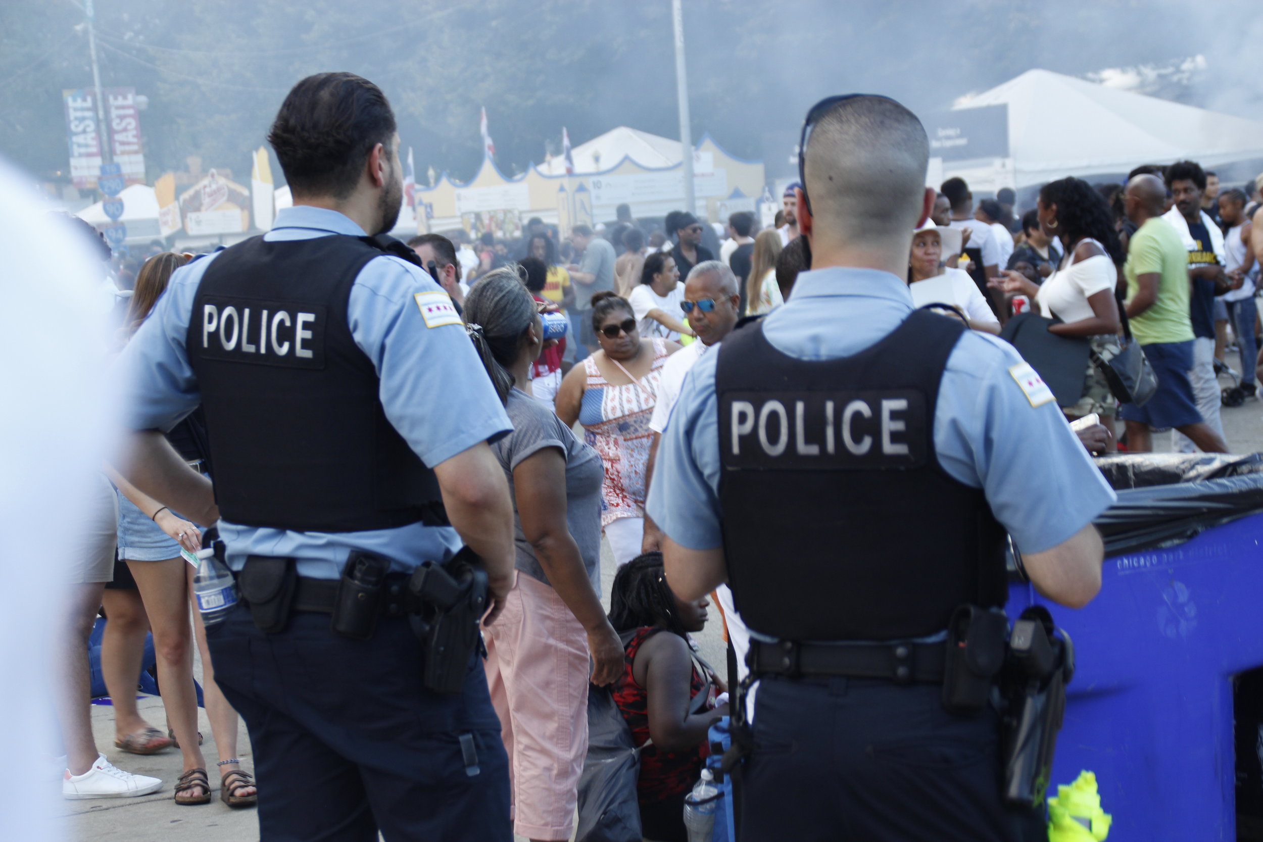  Police officers could be seen immersed in the crowds and off to the side monitoring the 39th annual Taste of Chicago. Each officer had a gun and other weapons around their waist including mace, handcuffs, and batons to use if necessary. 