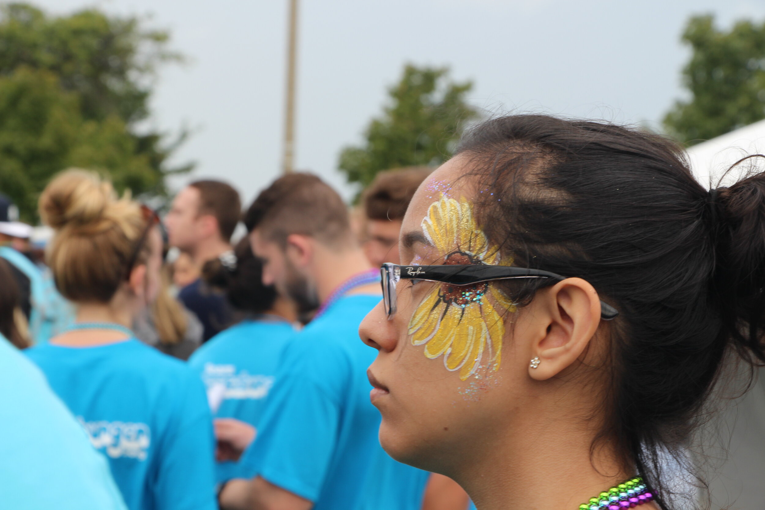 A participant wearing face-paint in the shape of a sunflower.