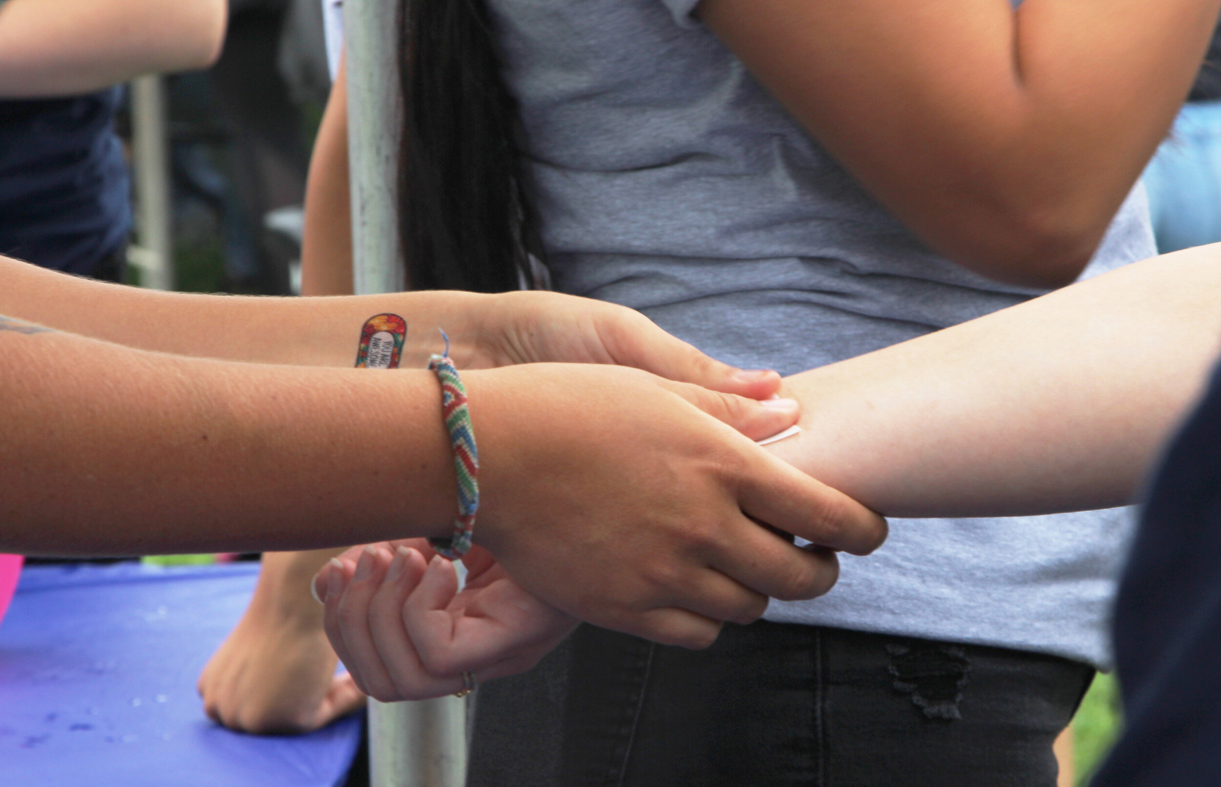  Volunteer wearing a temporary tattoo on the wrist giving the same tattoo to participants. 