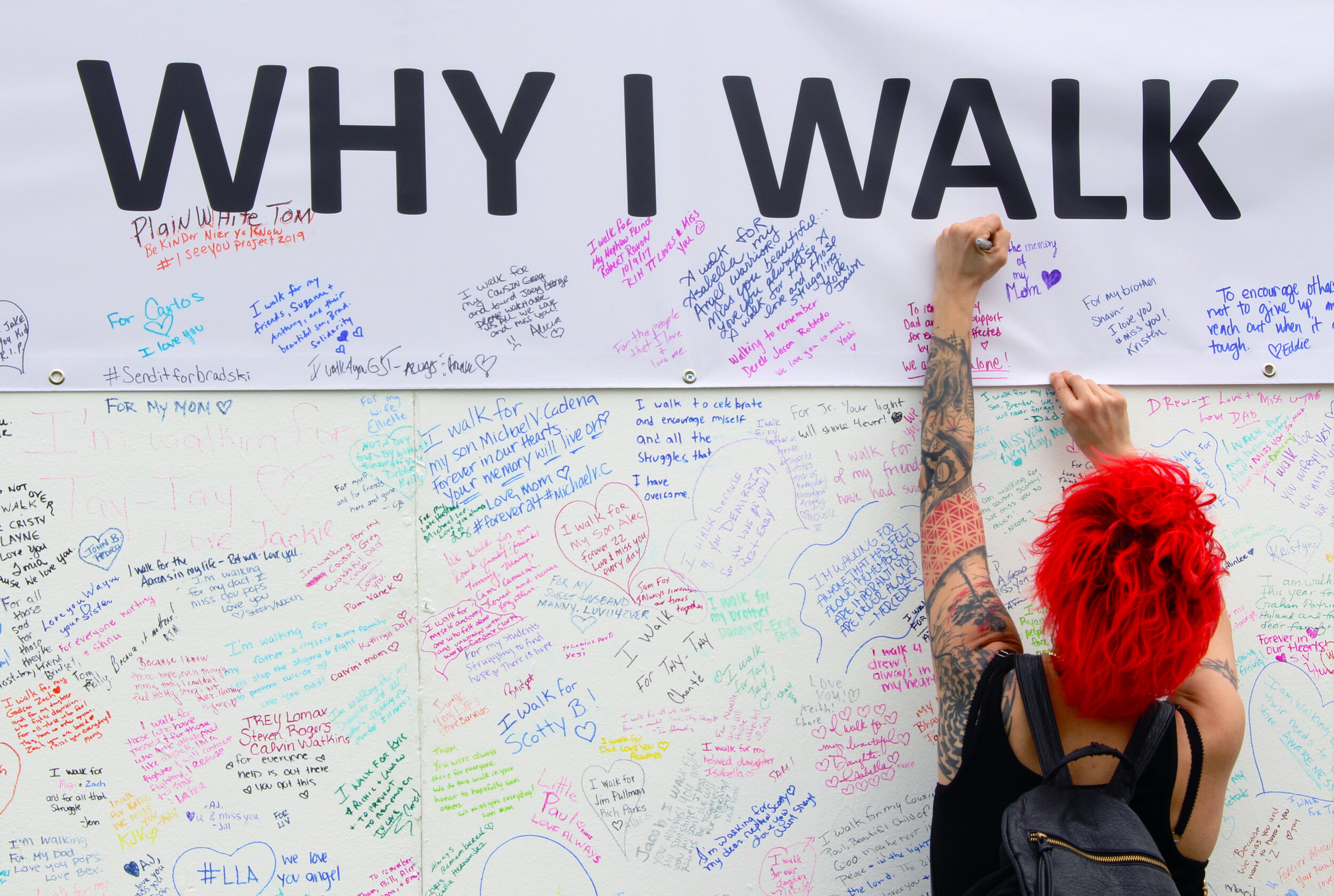  Participant writing a personal message on the  Why I Walk  wall. 