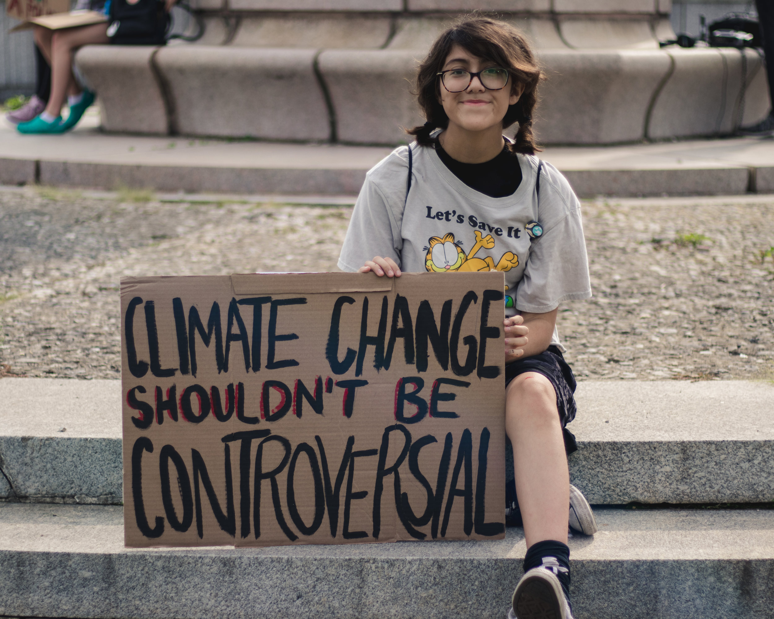 Naomi Avillas made the long trip from Naperville to Chicago. She sits with her sign waiting for the march to get underway.