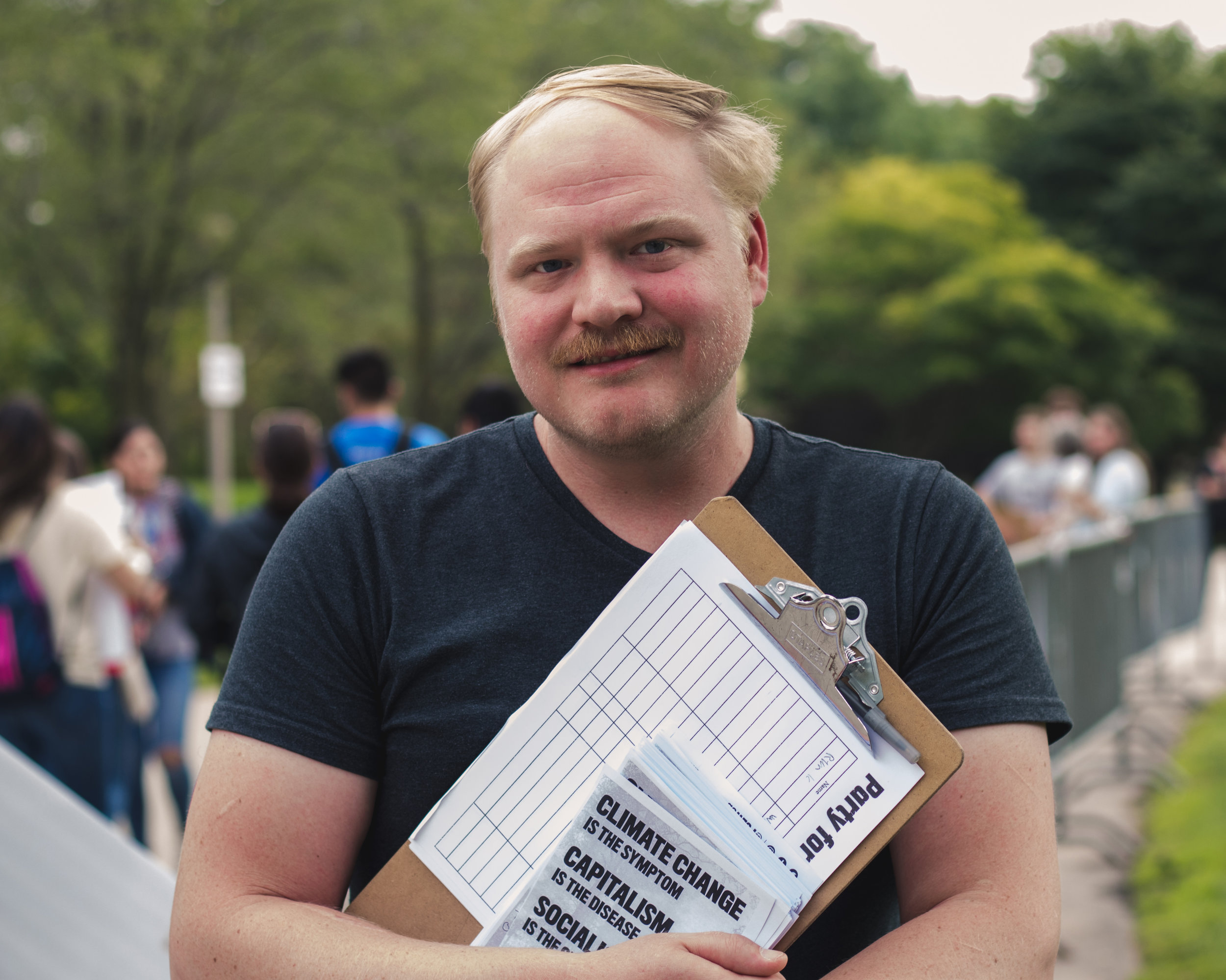Patrick McWillams passes out flyers about the Party of Socialism and Liberation to people arriving at the rally.