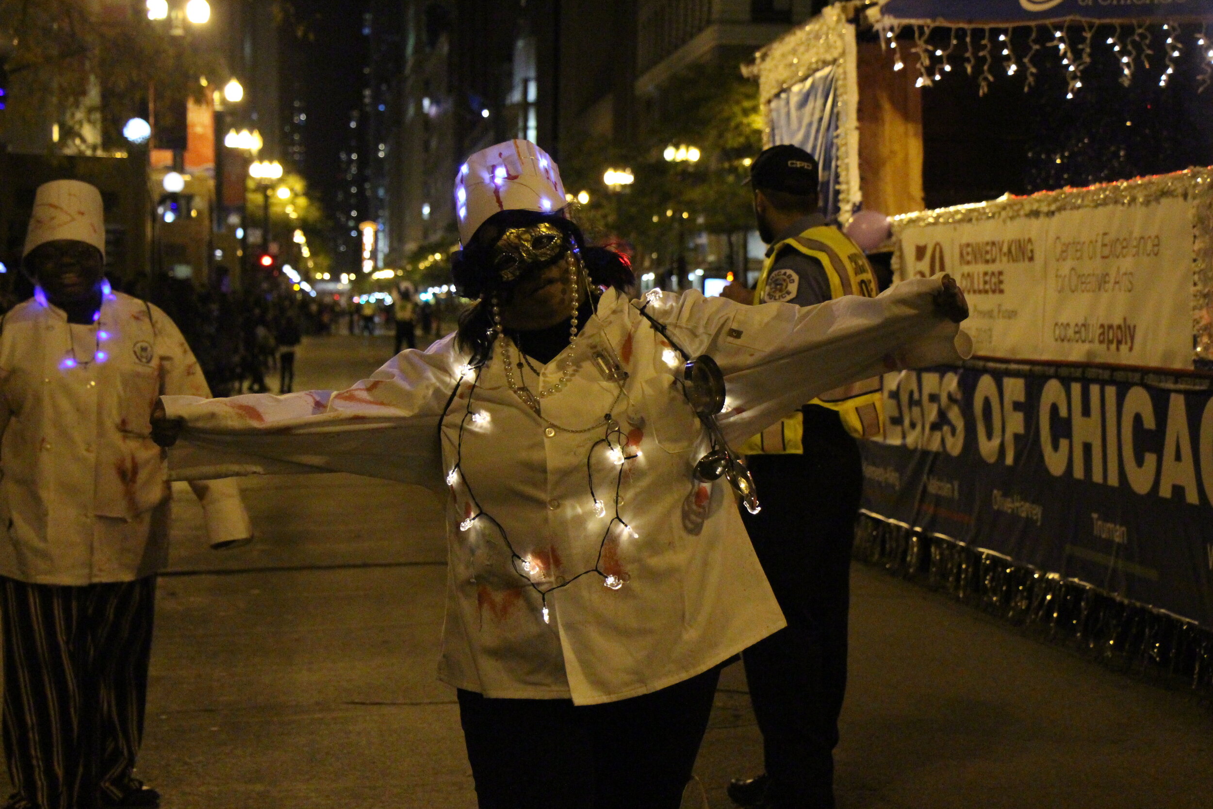 Attendees dressed up as bloody chefs glow as they pose to take a picture