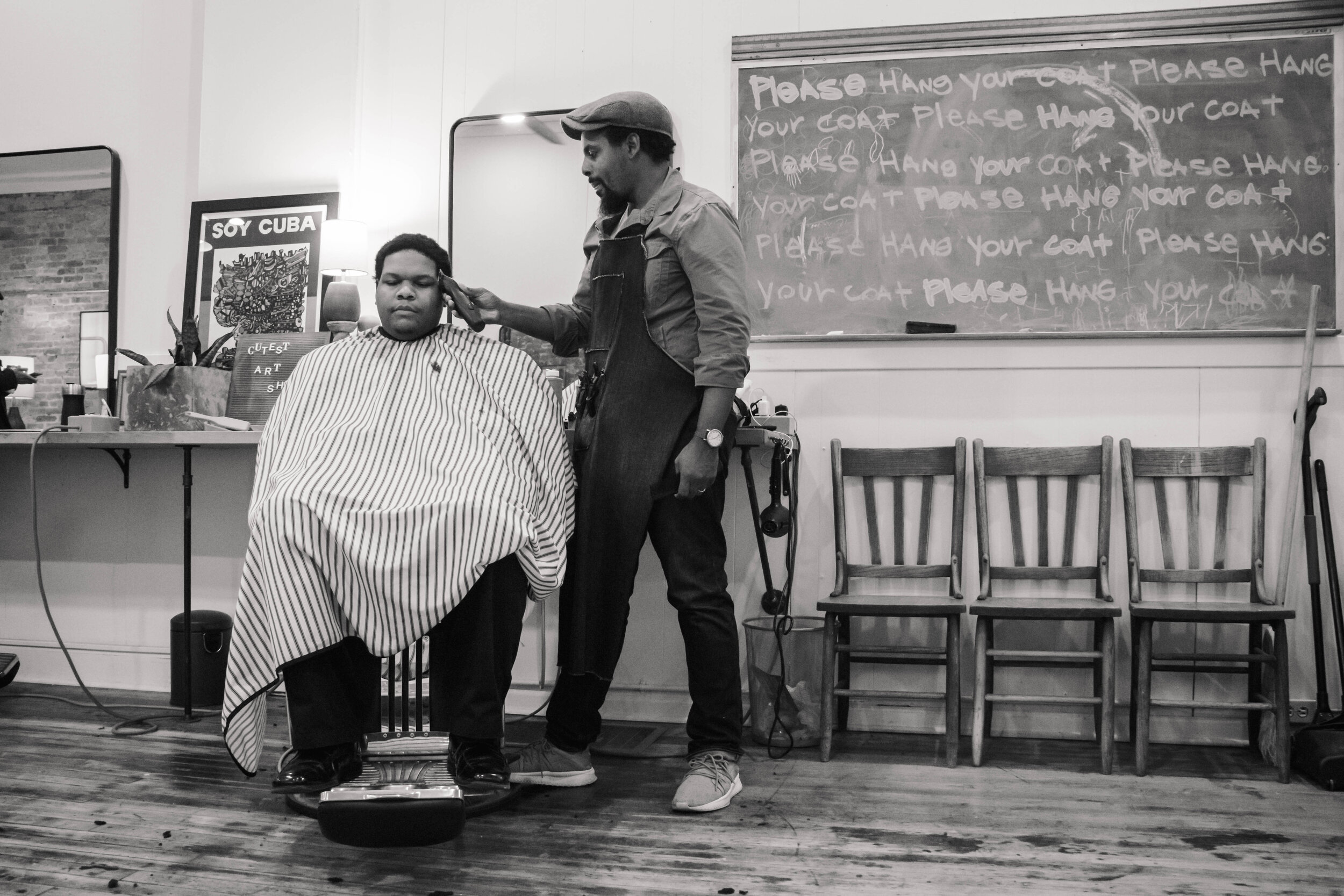  A new client sits in the chair, he just got off work and decided to stop at the barbershop before heading home.  