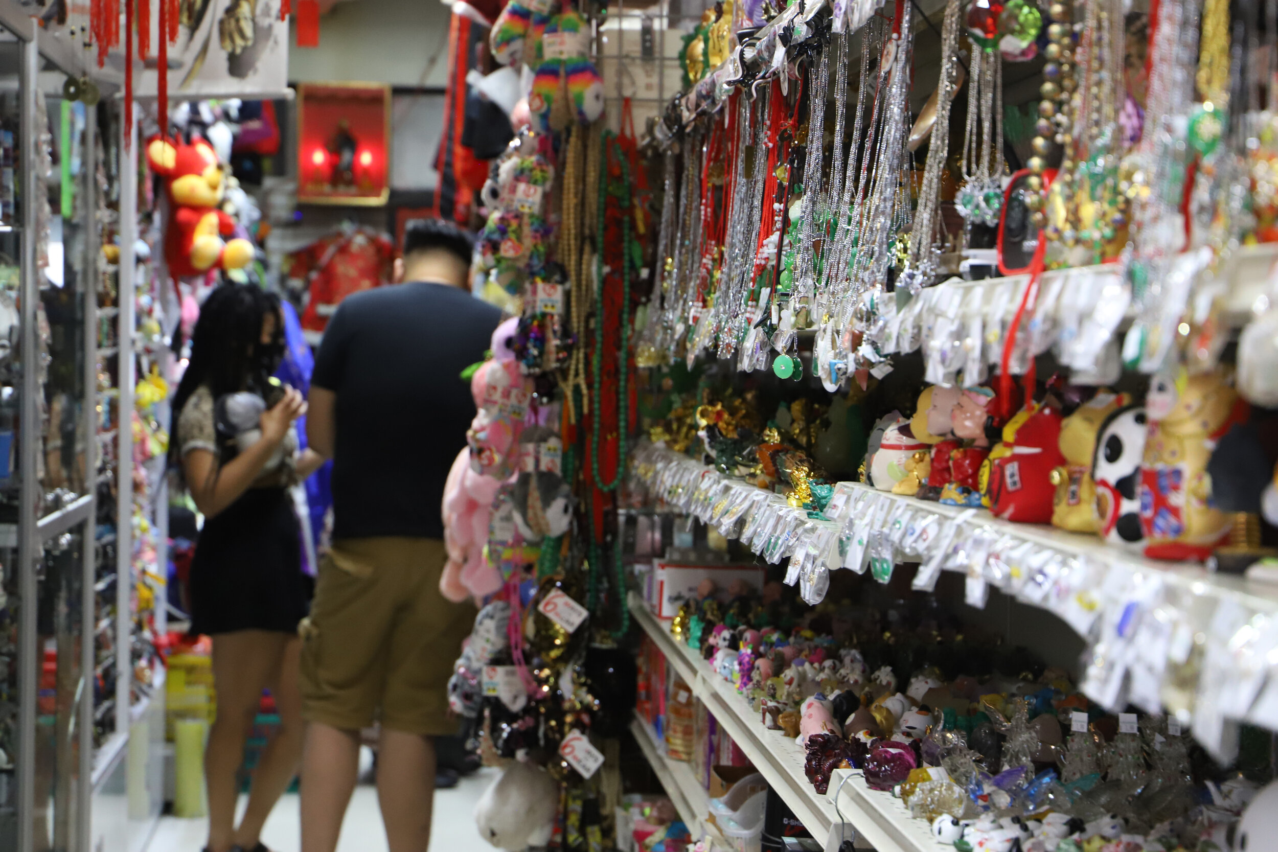  Two people wander around in a gift store in Chinatown. 