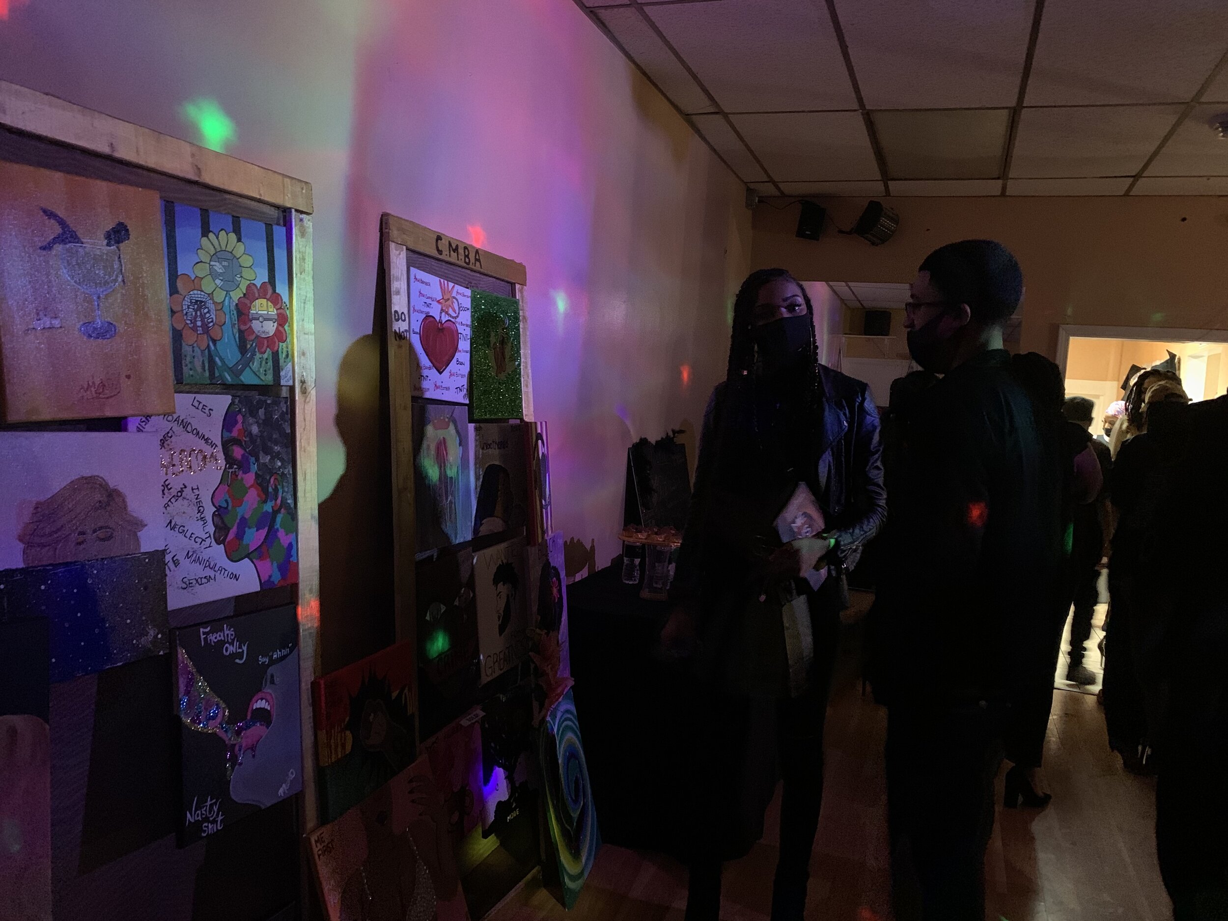  The attendees stop and gaze at the paintings for sale at the back of the room. The artwork in the photo was painted by Demetrice Rollins, the owner of Colour Me Bad Artistry. The photo was taken by Sabrina Hart.  “Last year, on my birthday, I felt l