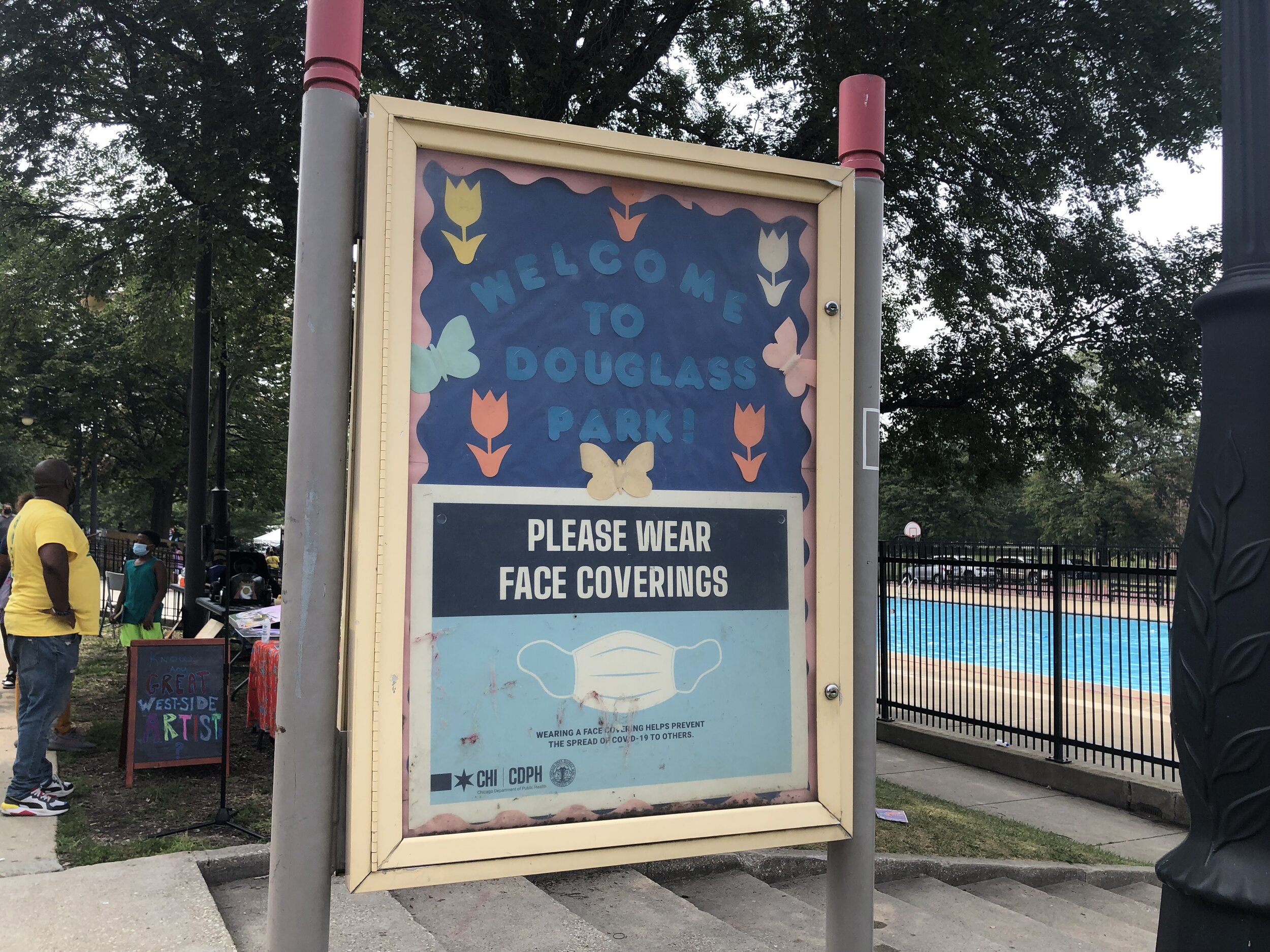 Douglass park sign reminding festival-goers to wear their face coverings.