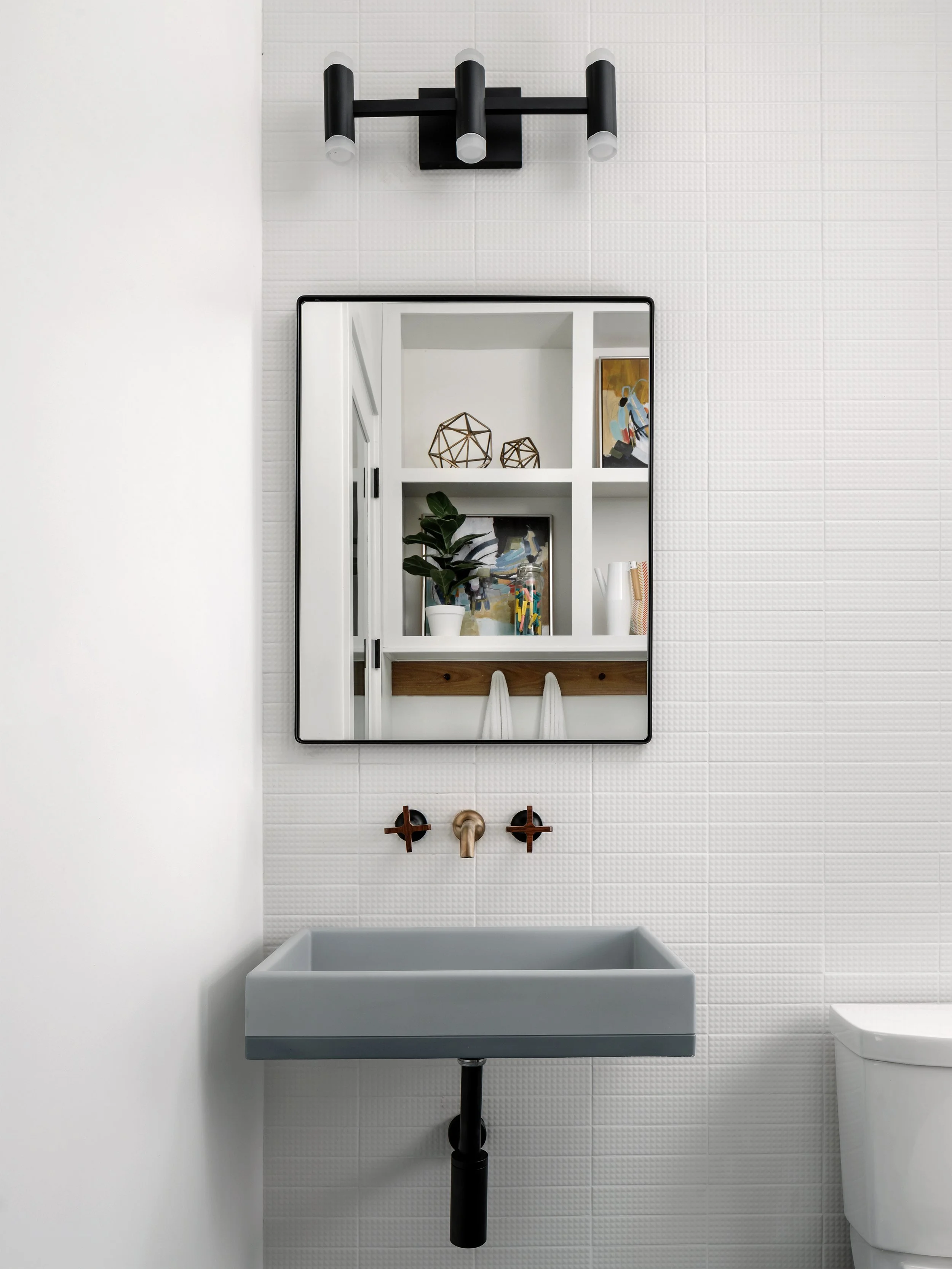 Modern bath with black framed mirror and bronze wall faucet, Breathe Design Studio