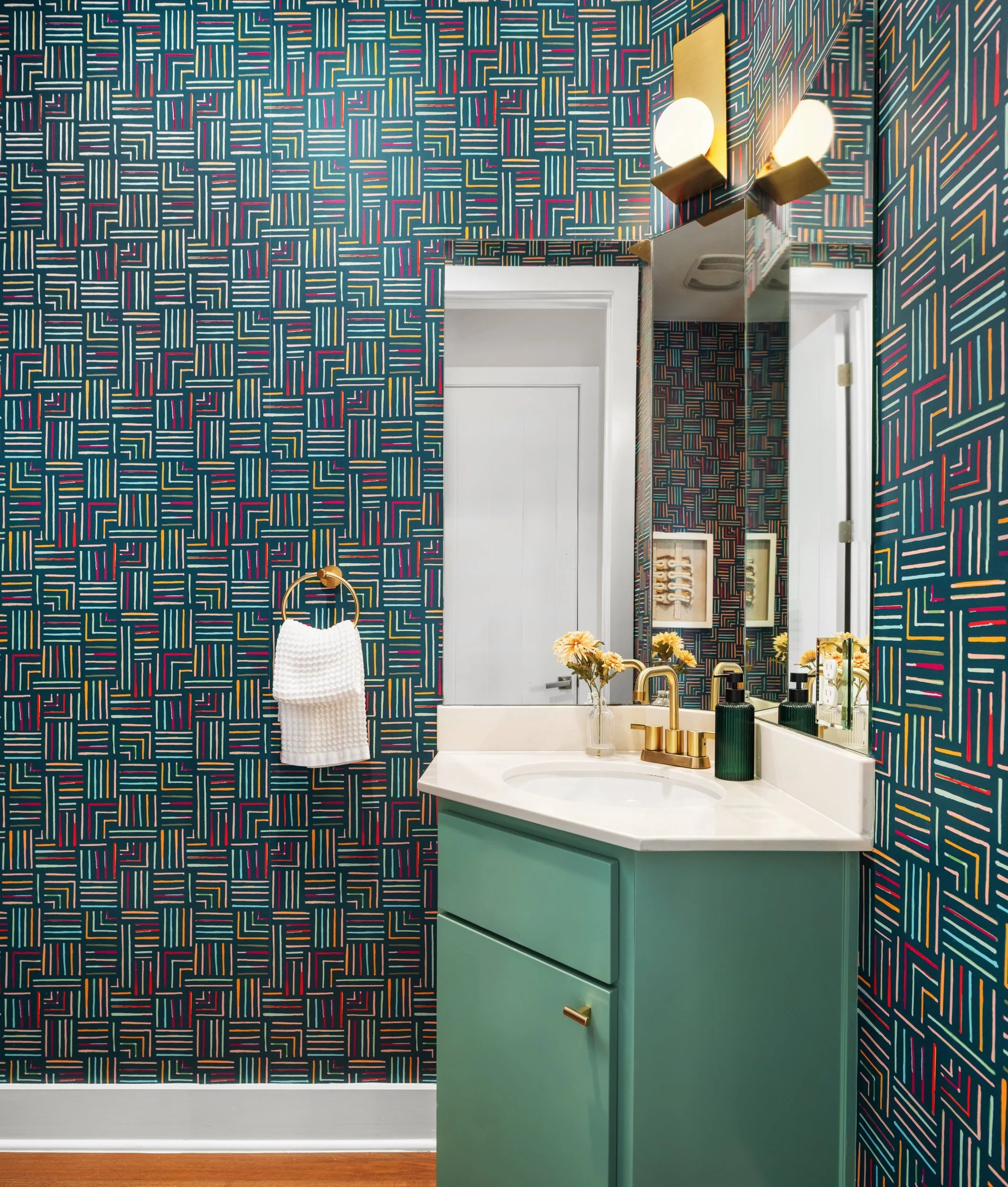 Powder room with patterned wallpaper and green vanity, Breathe Design Studio