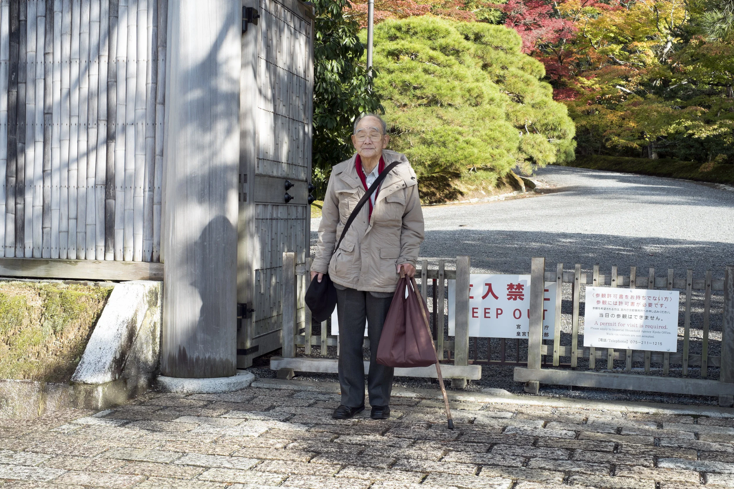An old gentleman has a photo taken by his wife as a memento in front of Katsura Imperial Villa, Kyoto, Japan