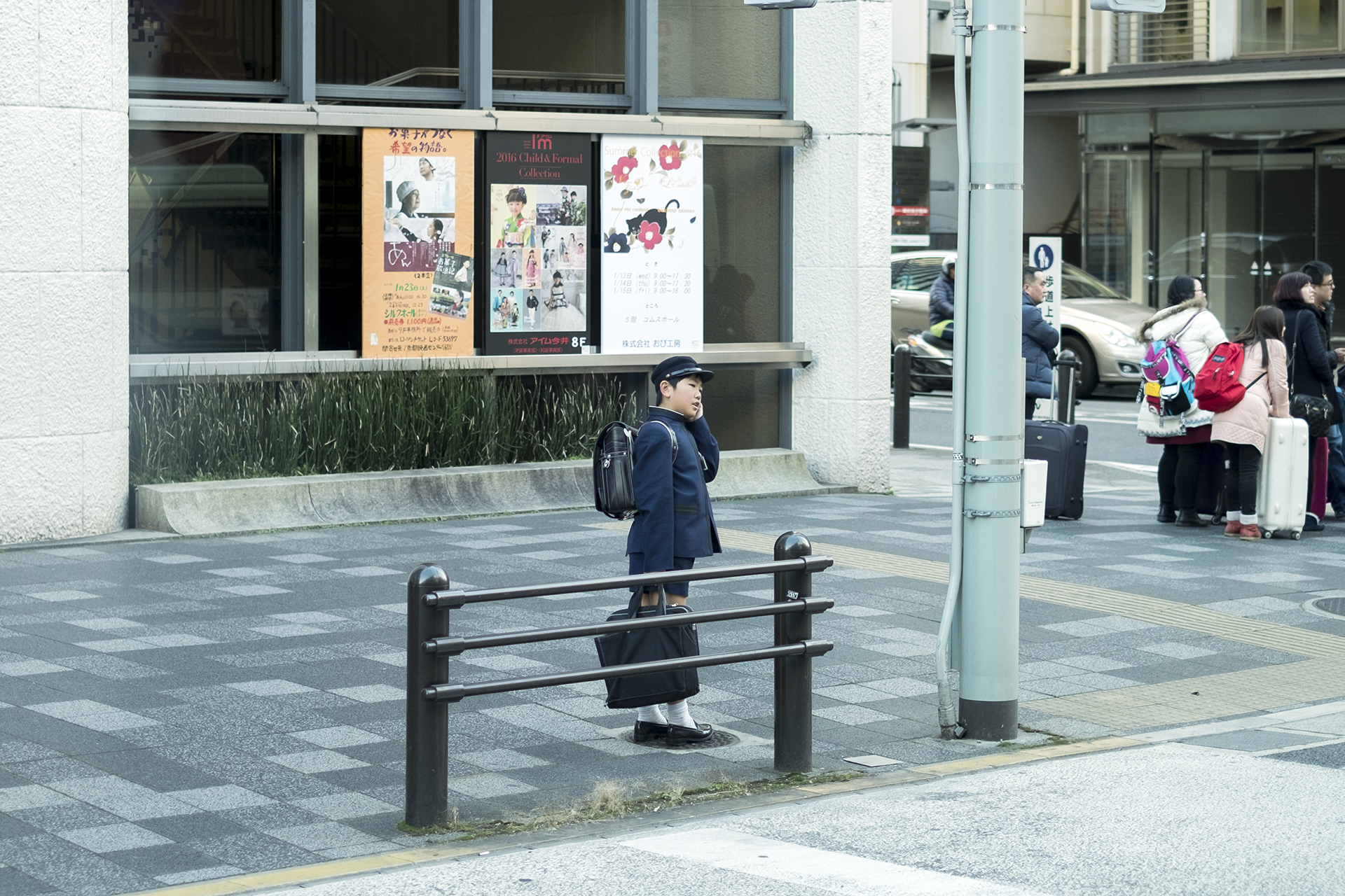 Primary school students calling his parent by mobile phone when he gets off the bus, Kyoto, Japan