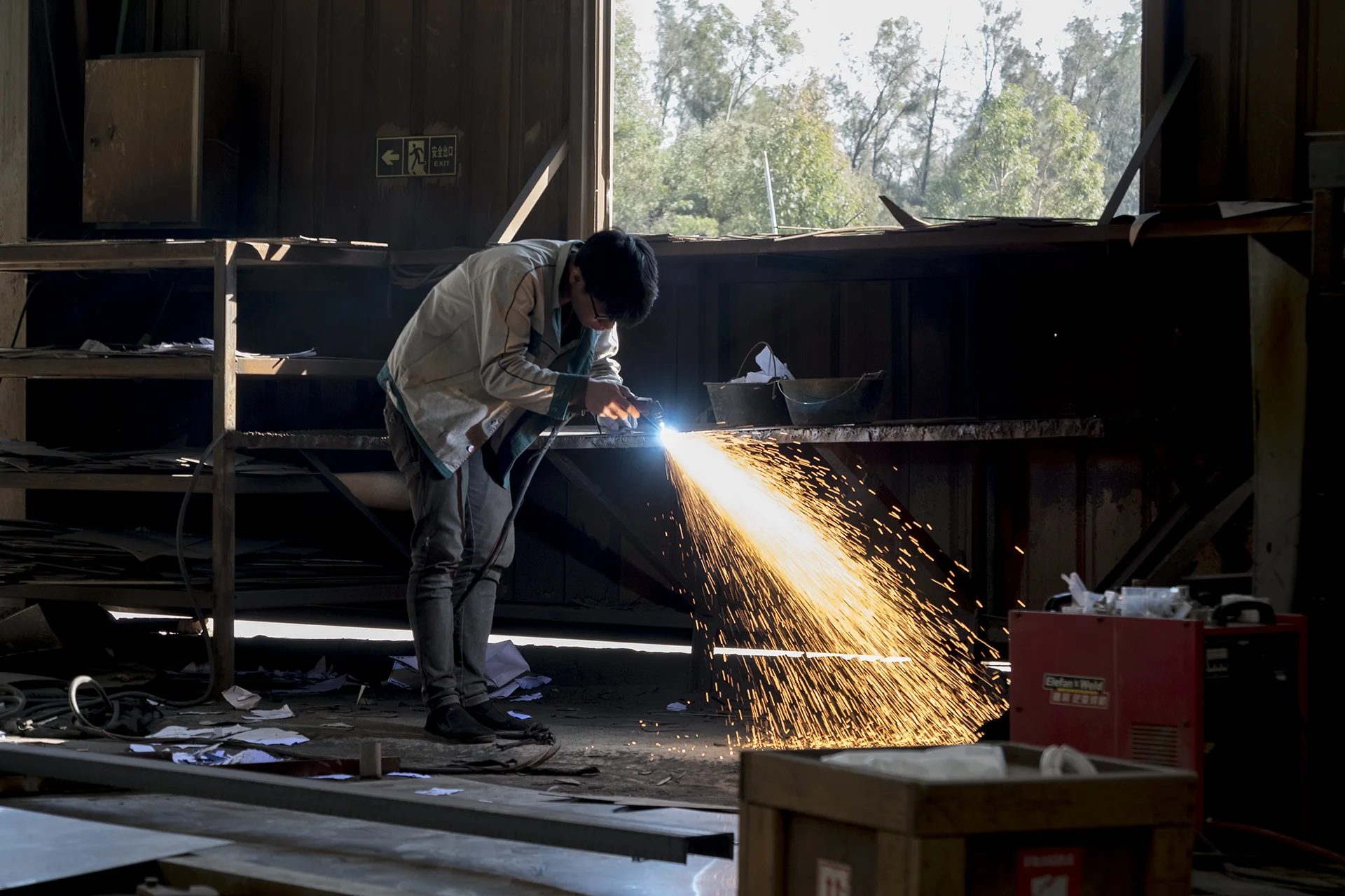Young worker works for a stainless steel sculpture in a factory, Xiamen, China