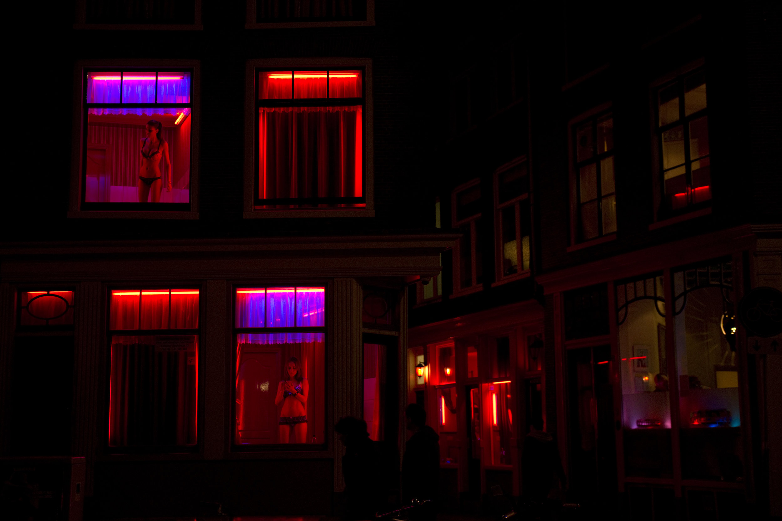  Two workers renting out rooms in Amsterdam's Red Light District,  De Wallen , wait for customers during the night. Prostitution is legal and strictly regulated in the Netherlands. 