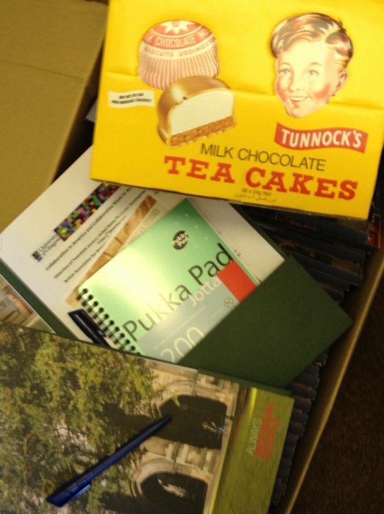 A UofG branded conference pack with a notebook and a large box of Tunnocks Tea Cakes