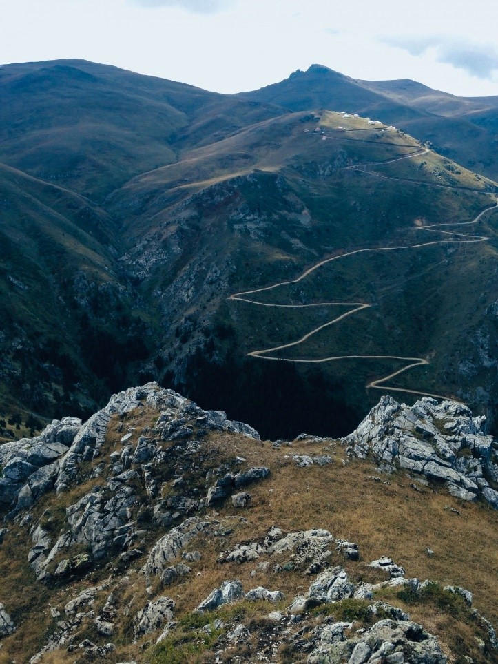 A mountain range with a road twisting through it.