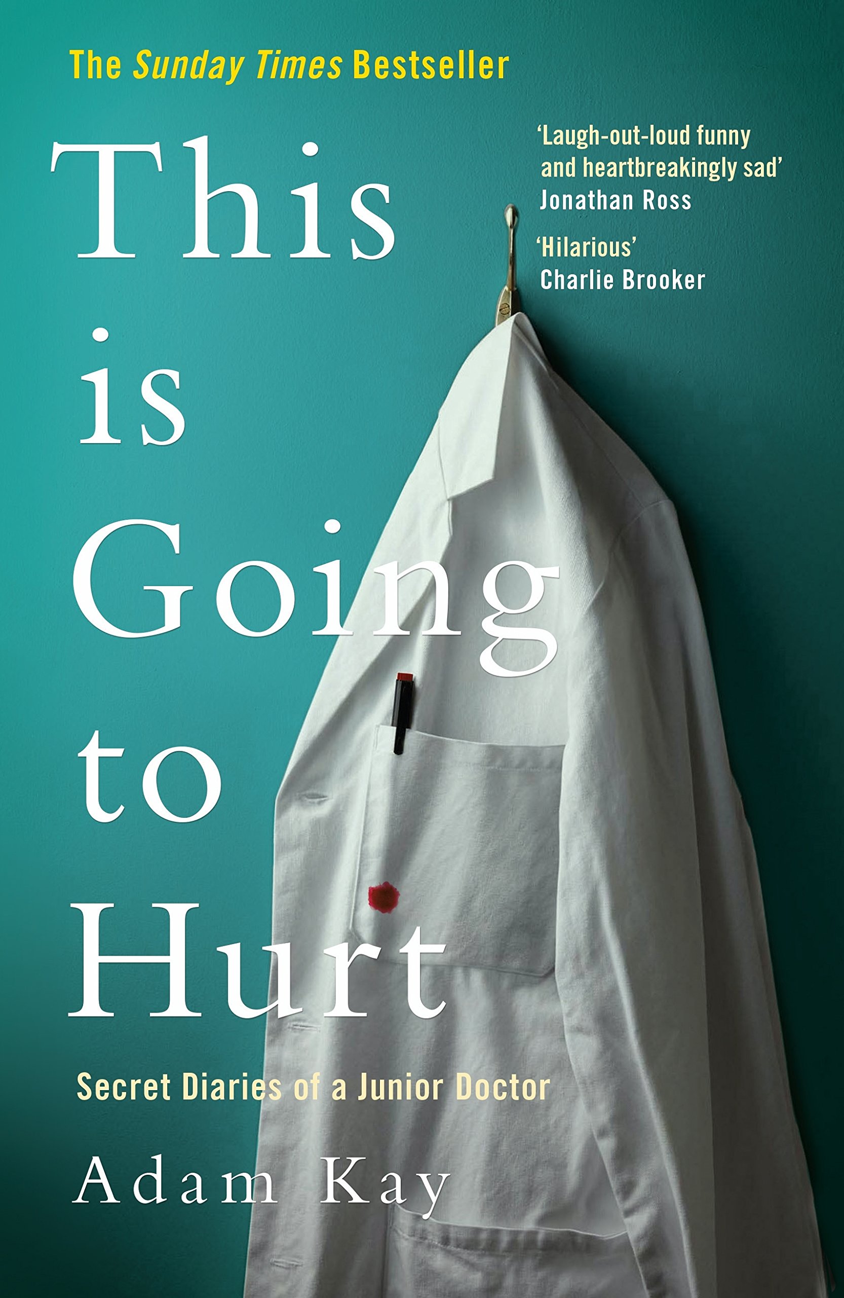 Front book cover of ‘This is Going to Hurt: Secret Diaries of a Junior Doctor’ by Adam Kay. The image displays a white lab coat hung up on a hook against a teal coloured wall. There is pen placed in the breast pocket of the coat, and a spot of blood on the pocket of the lab coat.