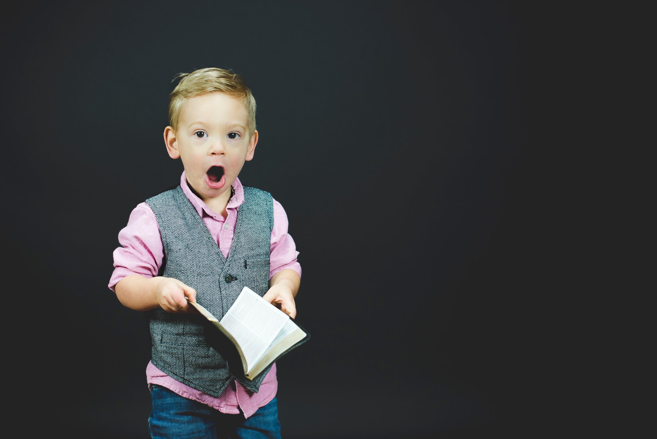 Boy looking shocked and holding an open book