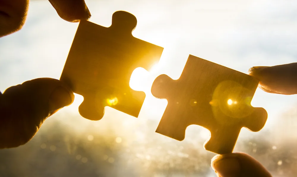 hands holding jigsaw pieces