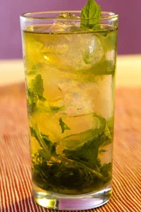 Mint Julep Mint and sugar cut sweetly through the robustness of bourbon in this delicious cocktail. Traditionally served in pewter cups, it is in fact a pre-Prohibition drink, which probably originated in the southern United States in the 18th century. But it soon started to trickle northwards, and survived Prohibition to become the official drink of the Kentucky Derby. The drink is mentioned twice in The Great Gatsby, most noticeably when Daisy, Tom and Gatsby have a row in a hotel. “I’ll make you a mint julep,” Daisy tells her husband. “Then you won’t seem so stupid to yourself.” You’’ll hopefully drink yours in less tense surroundings. Mix a teaspoon of sugar (you can adjust to taste) with a splash of water in a highball glass or pewter cup until dissolved. Add a handful of mint leaves (I'd suggest around 10) and gently bruise with a muddler or wooden spoon. Fill the glass with crushed ice, then pour in 60-90ml of bourbon, depending on the size of your glass. Stir, top up the glass with more crushed ice, and garnish with a few more mint leaves.