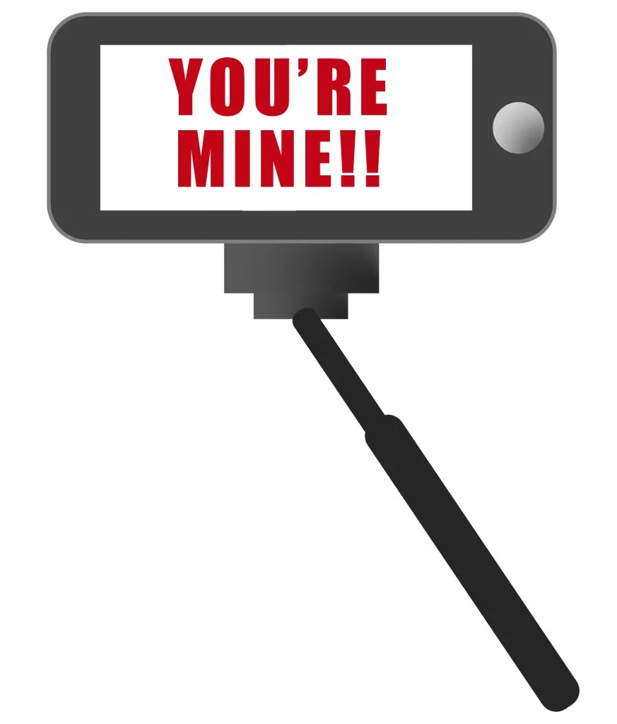 Selfie stick and phone with "You're mine!" on the screen