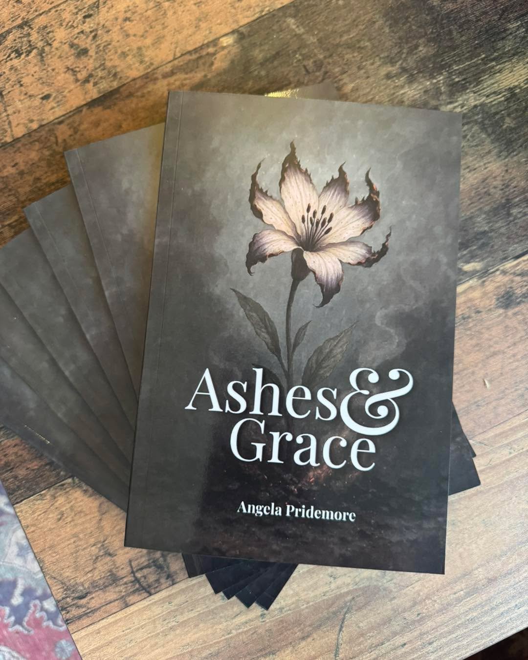 Happy book birthday to Ashes &amp; Grace by Angela Pridemore! 🎉 
Copies are available in the shop now! 

Ashes &amp; Grace explores what it means to shine light in dark spaces without being consumed by them. Set against the backdrop of small-town Ap