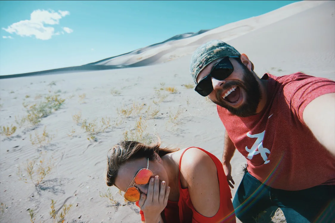 get u a travel buddy who takes selfies of you while you're cowering for shelter during a sandstorm